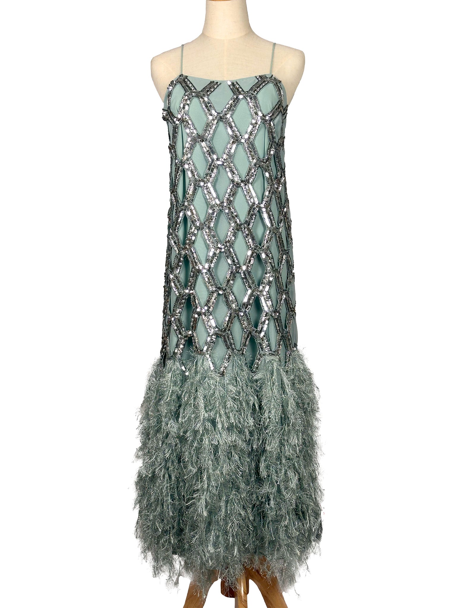 Dress with sequin top and feather skirt on a mannequin against a white background