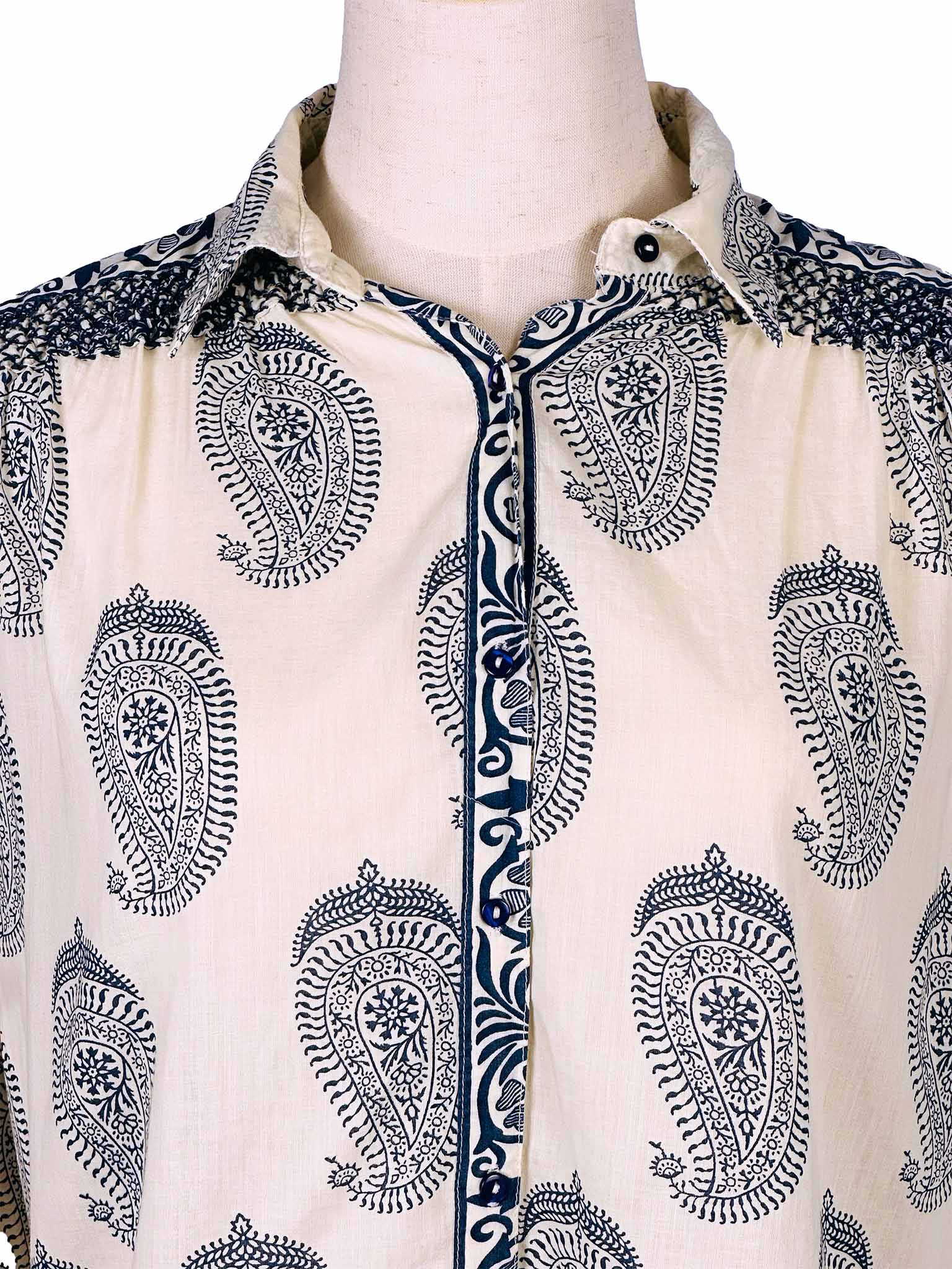 White shirt with dark blue paisley pattern on a mannequin against a white background