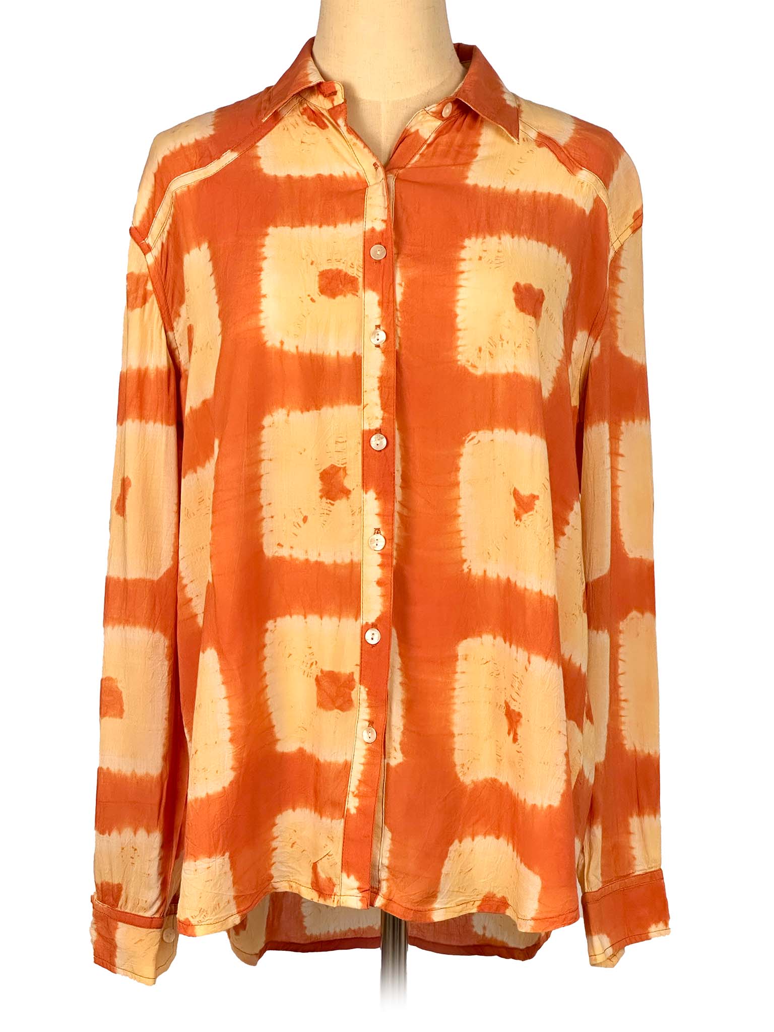 Orange and beige tie-dye shirt on a mannequin against a white background