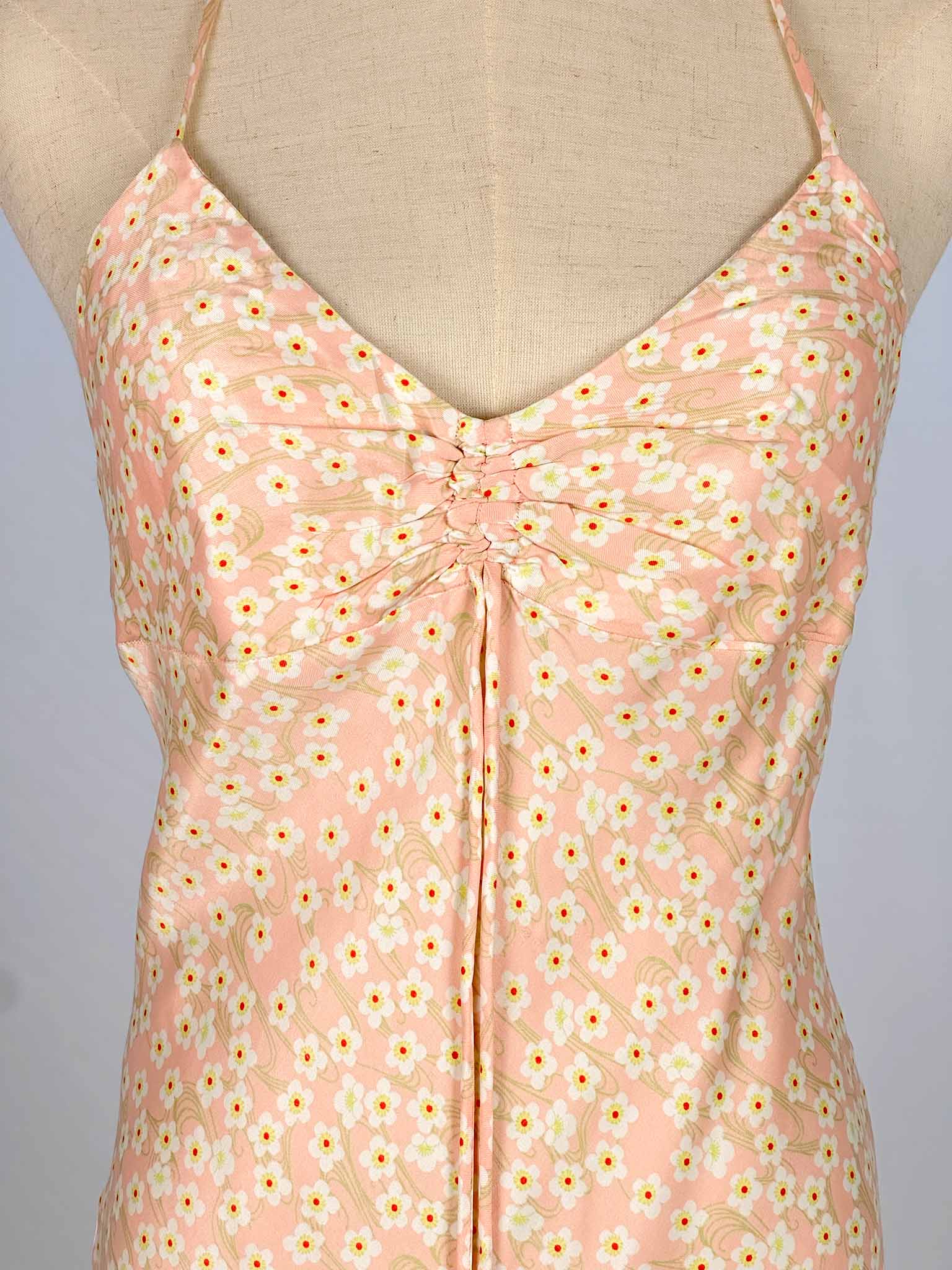 Floral-patterned pink dress on a mannequin with a neutral background
