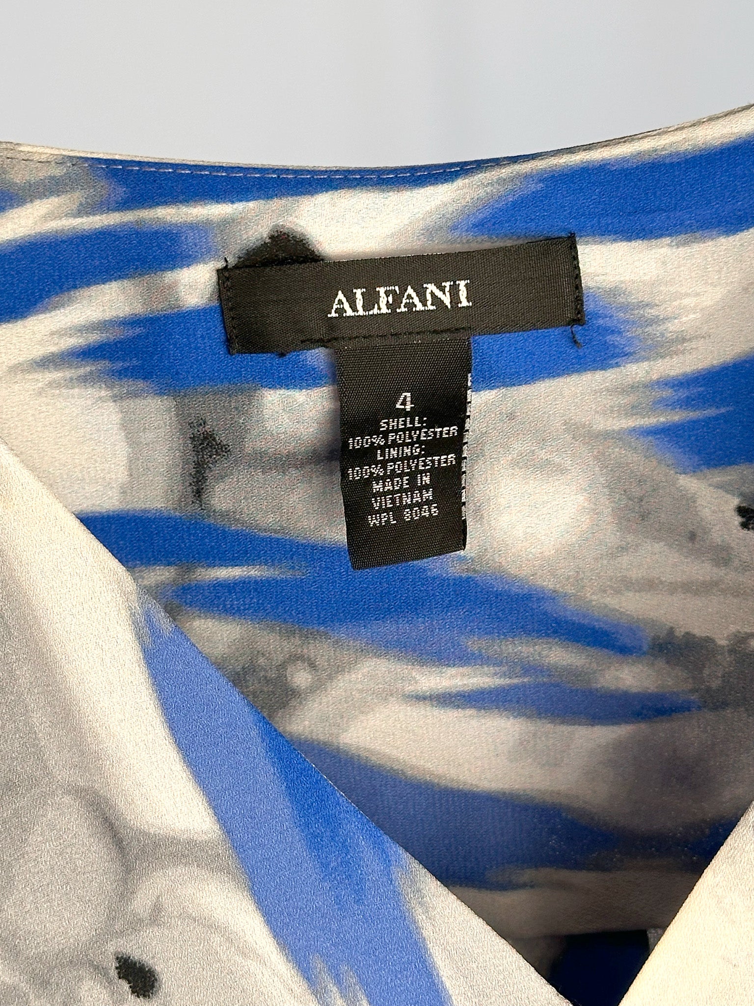 Close-up of a label on a garment with 'Alfani' branding.