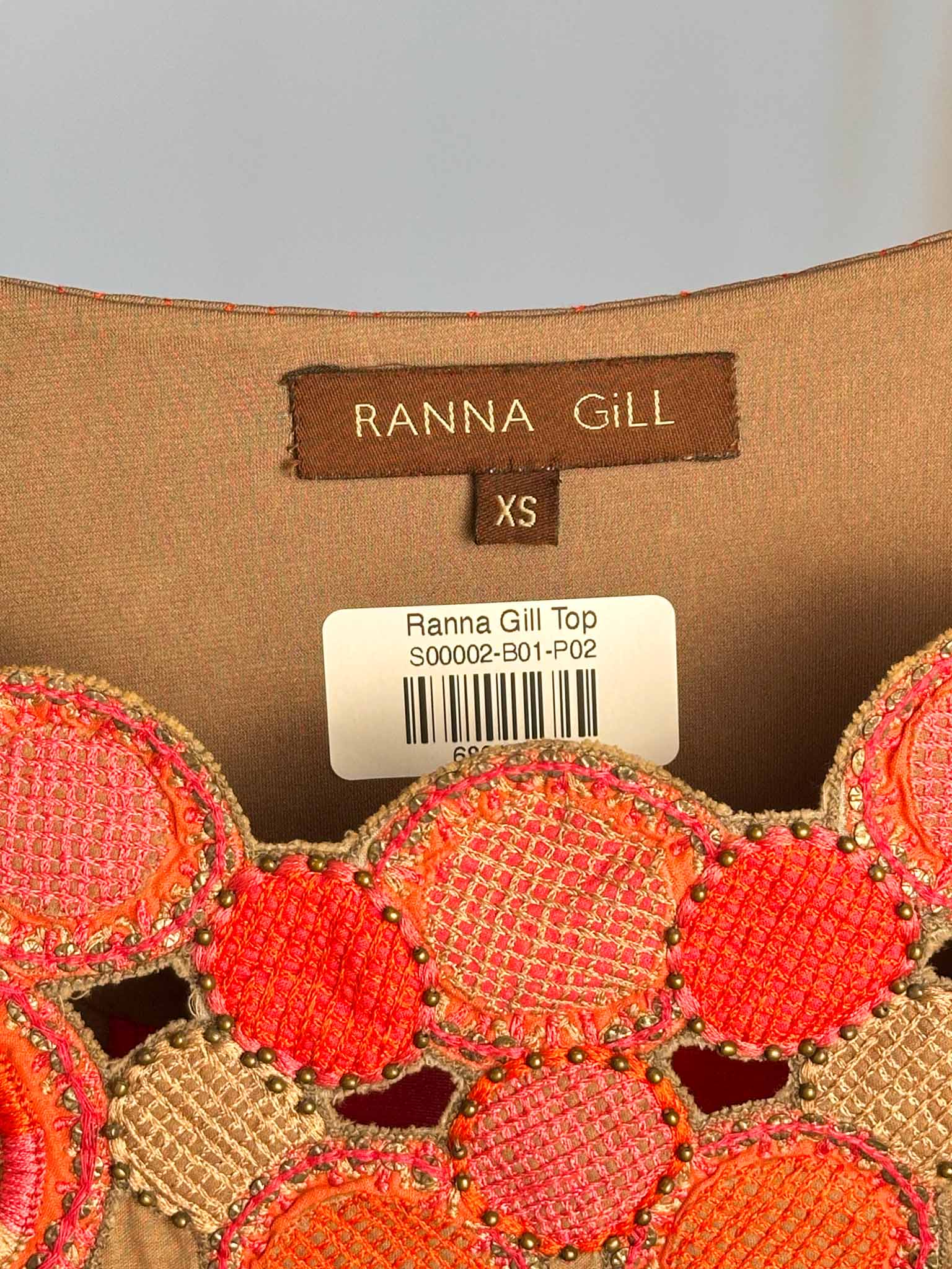 Close-up of a Ranna Gill top with label and decorative patterns
