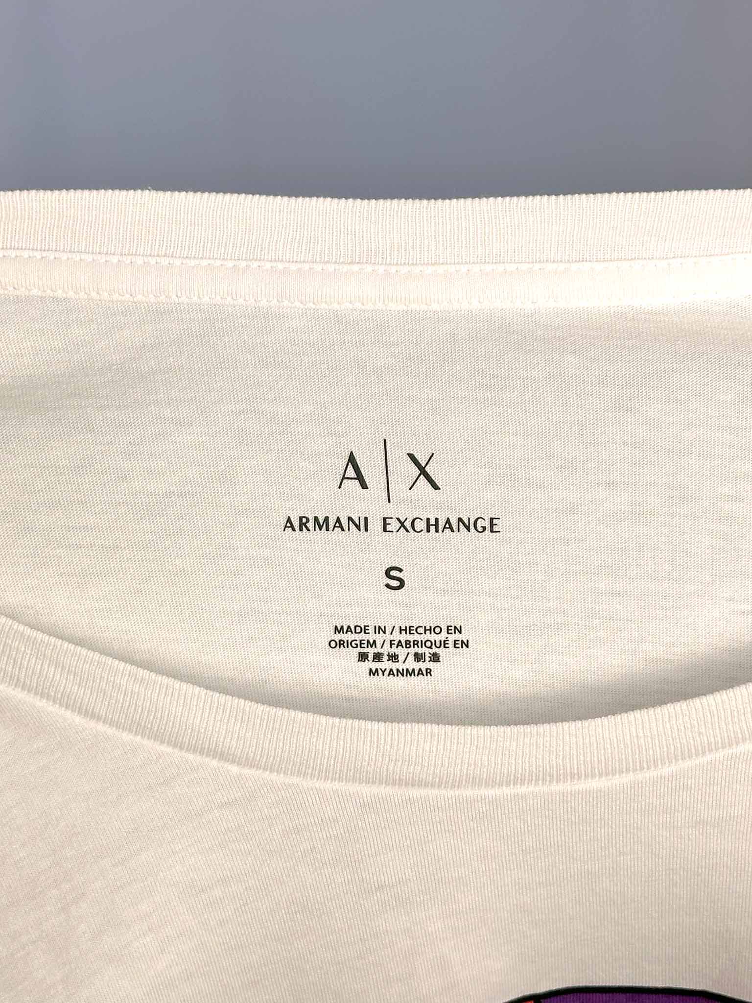Close-up of Armani Exchange label on a white garment with a gray background