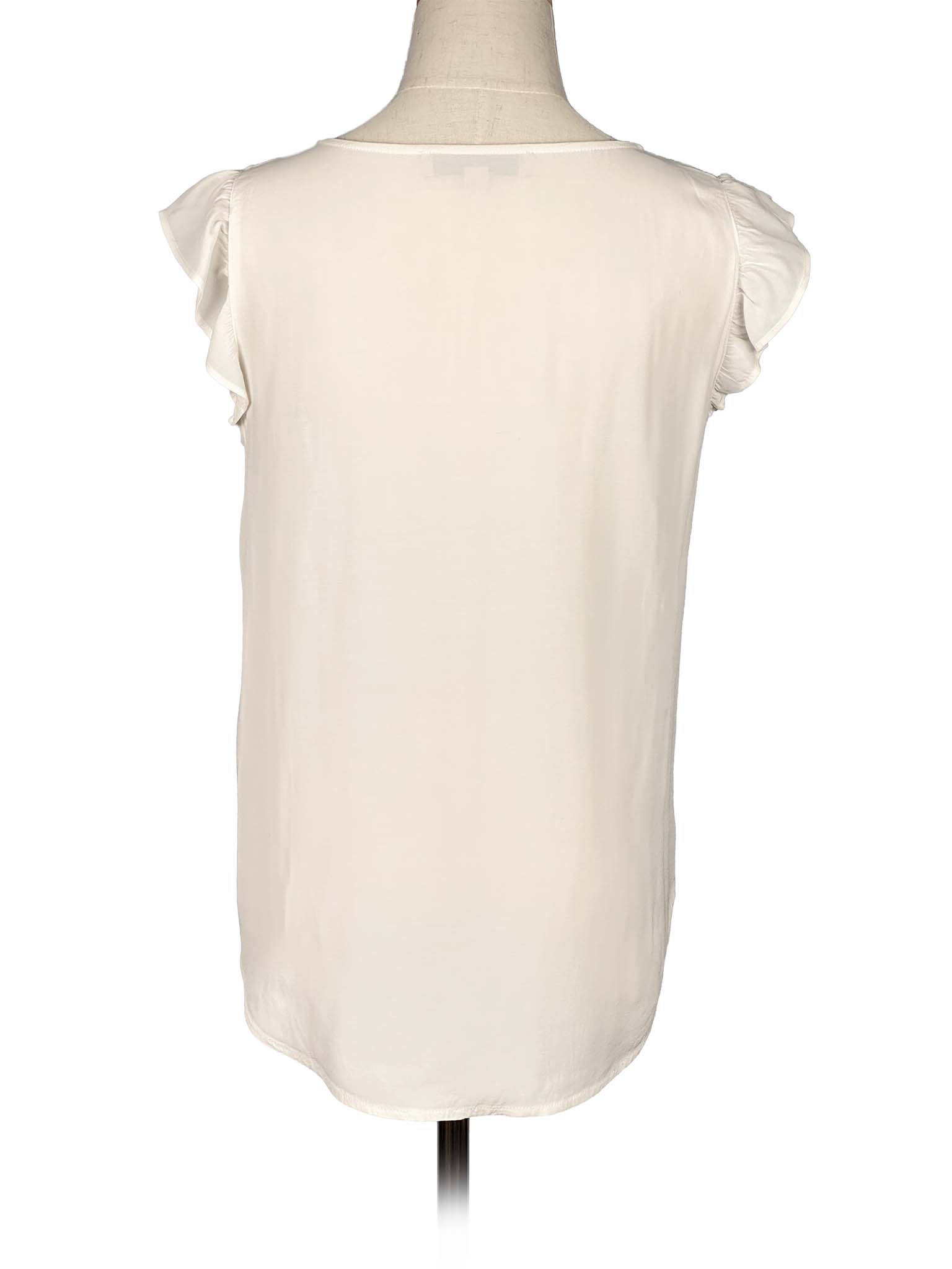 White sleeveless Loft top with ruffled shoulders on a mannequin against a white background