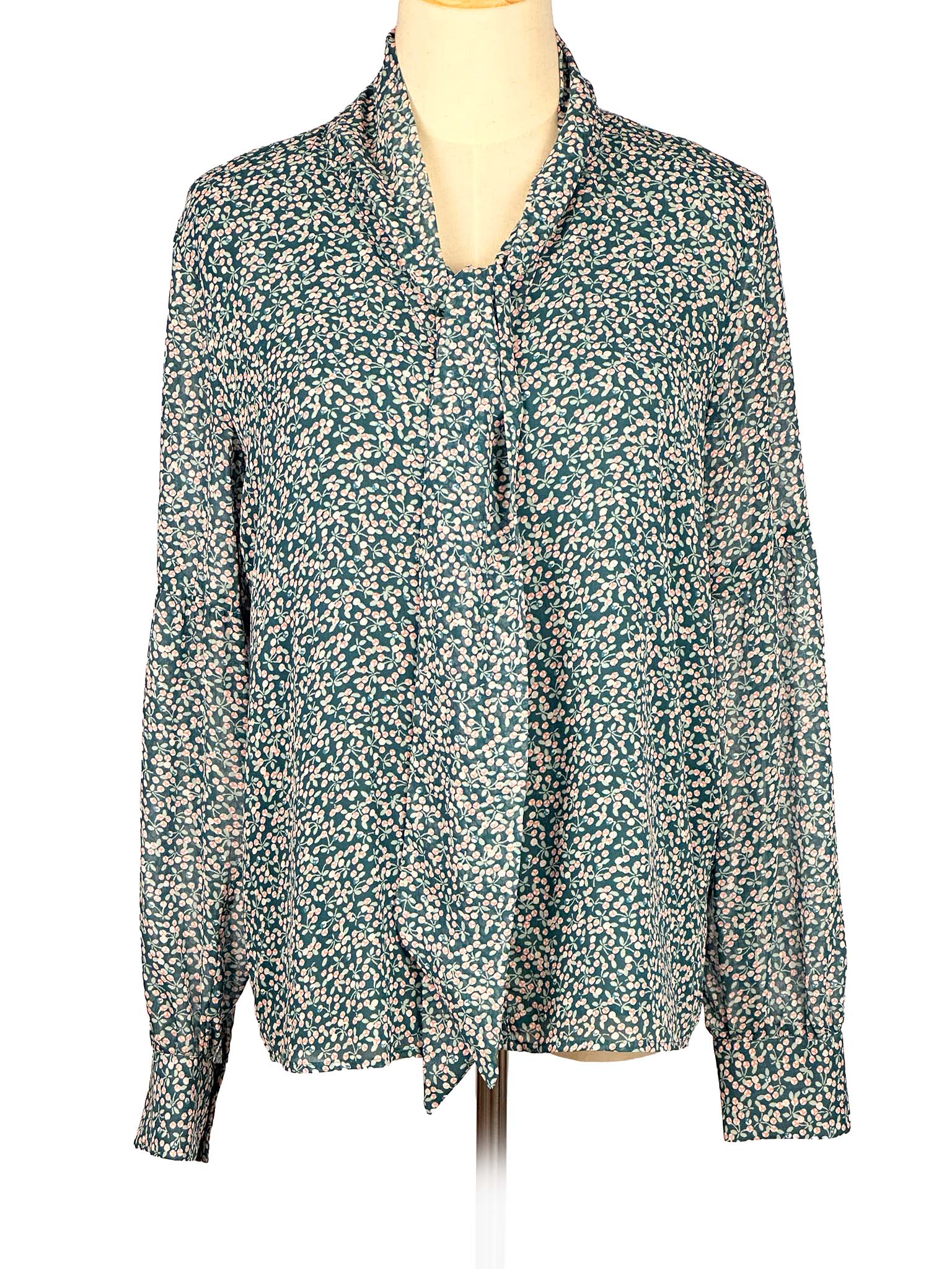 Floral-patterned green Loft blouse on a mannequin against a white background