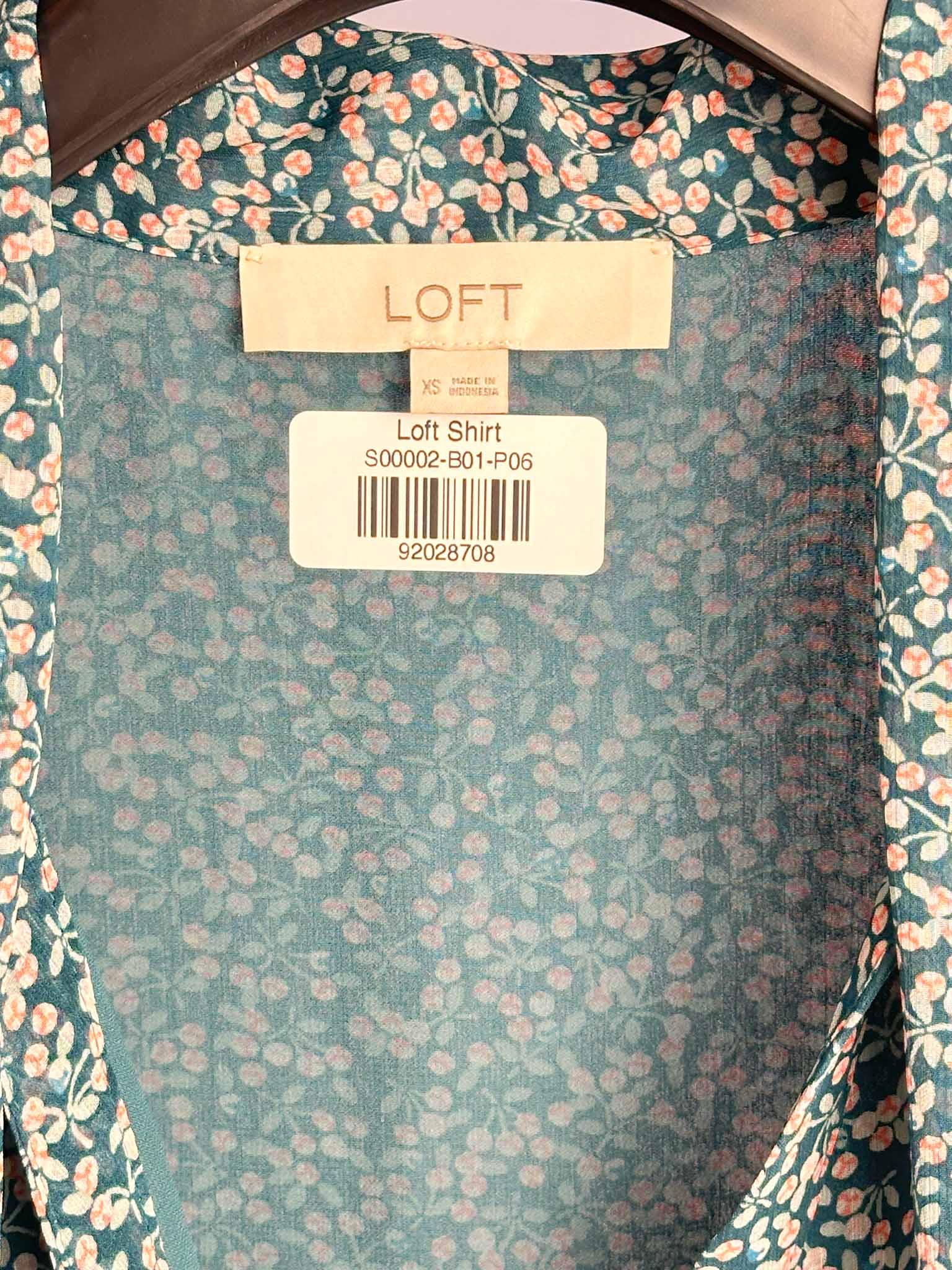 Floral-patterned shirt with a LOFT label on a matching background