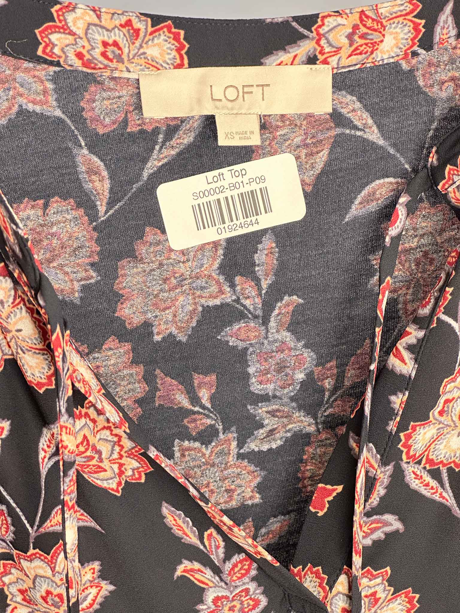 Floral patterned top with LOFT label on a gray background