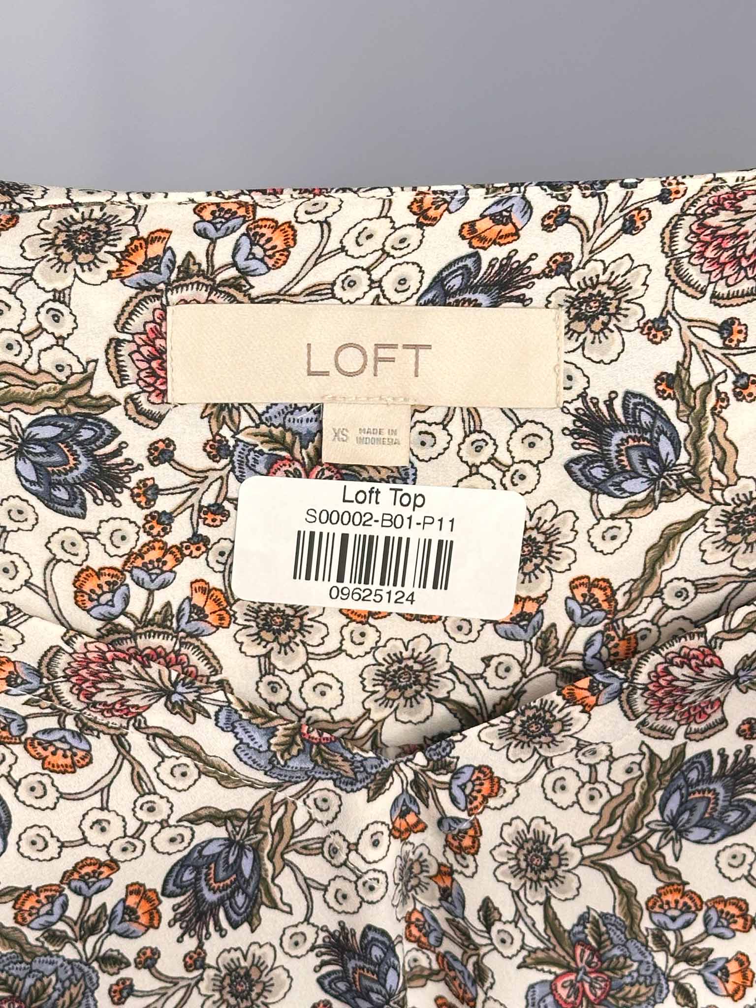 Floral-patterned fabric with a LOFT label on a gray background