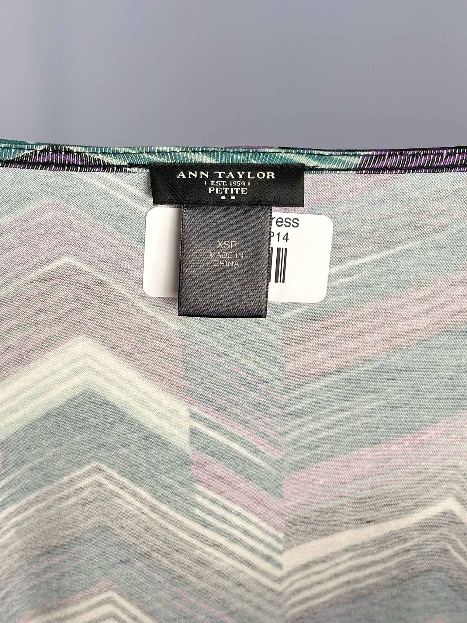 Close-up of a patterned fabric with an Ann Taylor label on a gray background