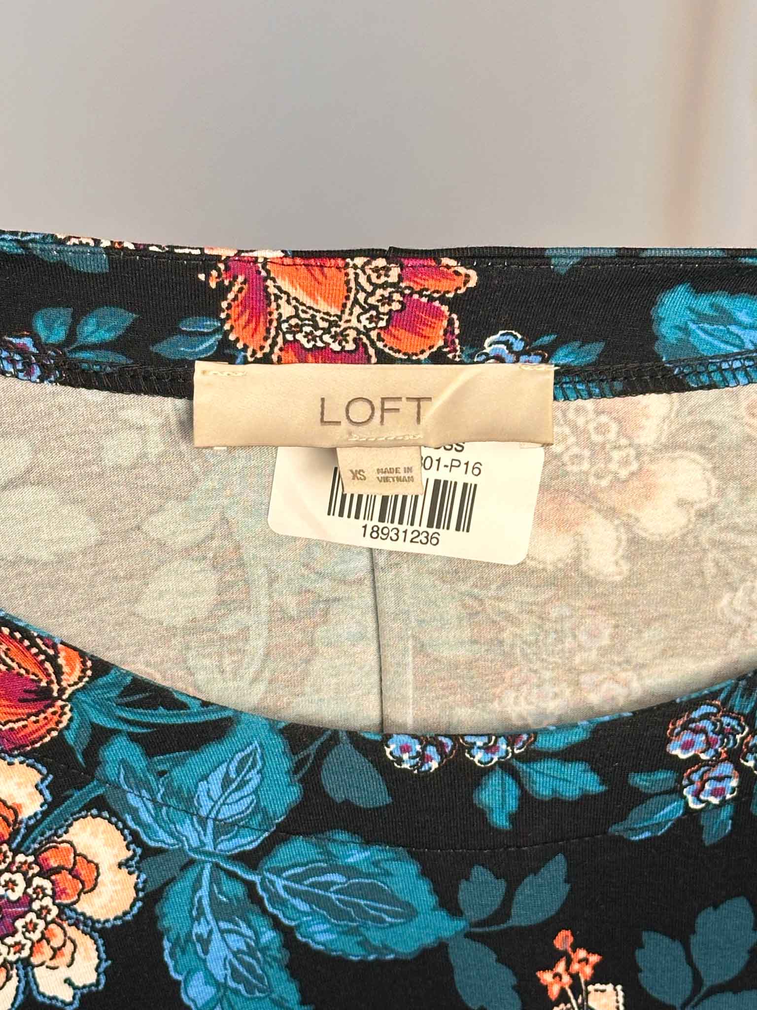 Floral-patterned fabric with a LOFT label on a gray background