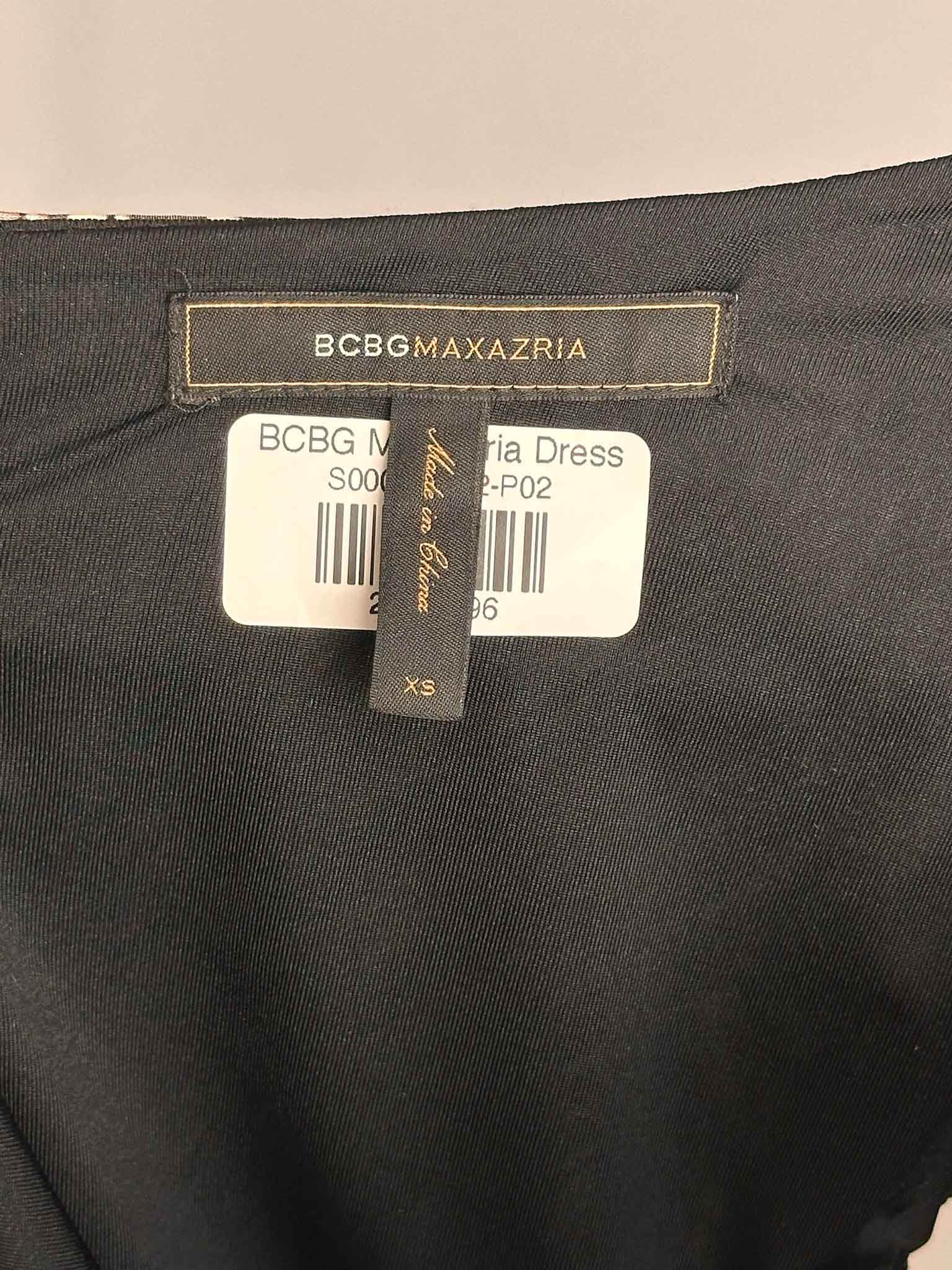 Black dress with BCBG Max Azria label on a beige background