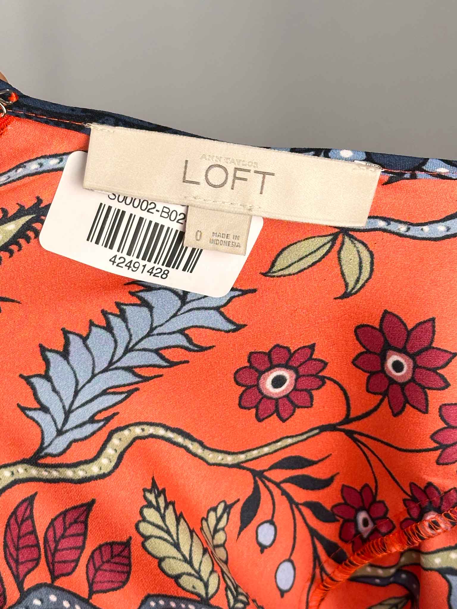Floral-patterned fabric with LOFT label on a gray background