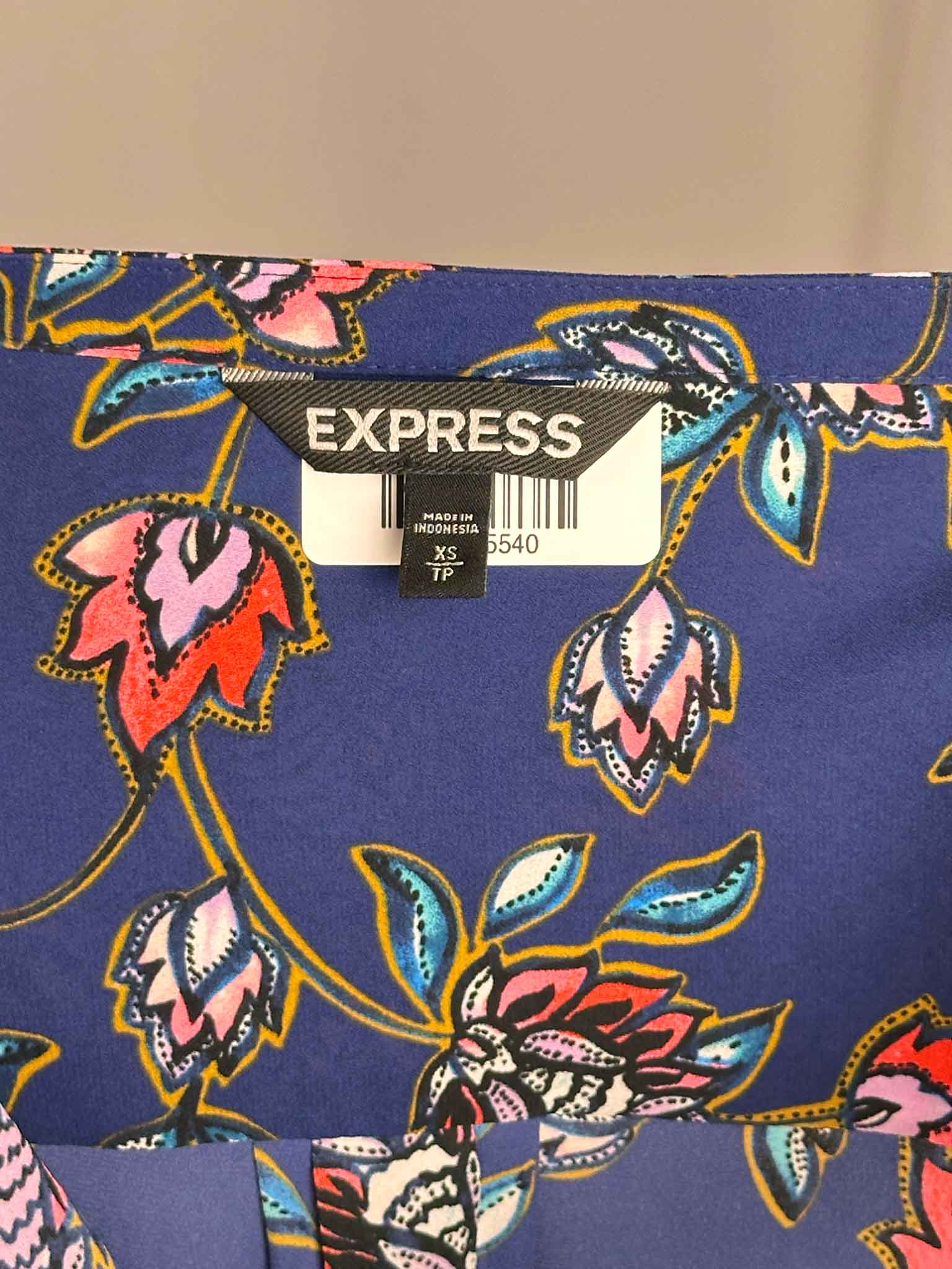 Floral patterned fabric with an Express label on a beige background