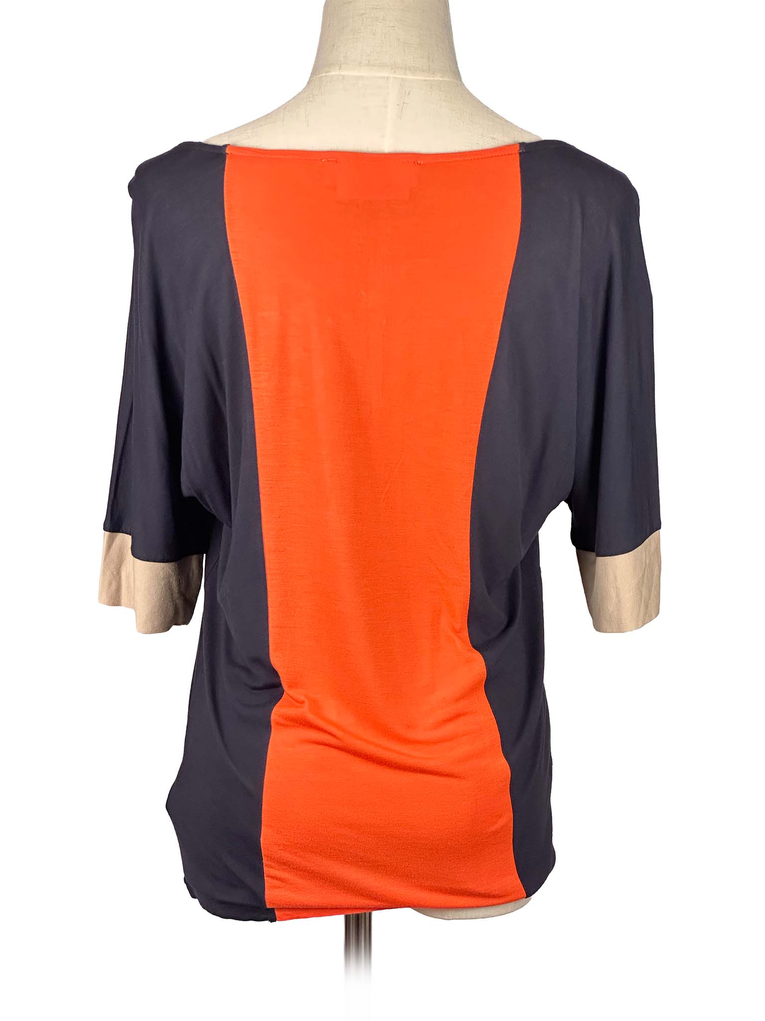 Mannequin wearing a two-tone Michael Kors shirt with orange and black sections on a white background