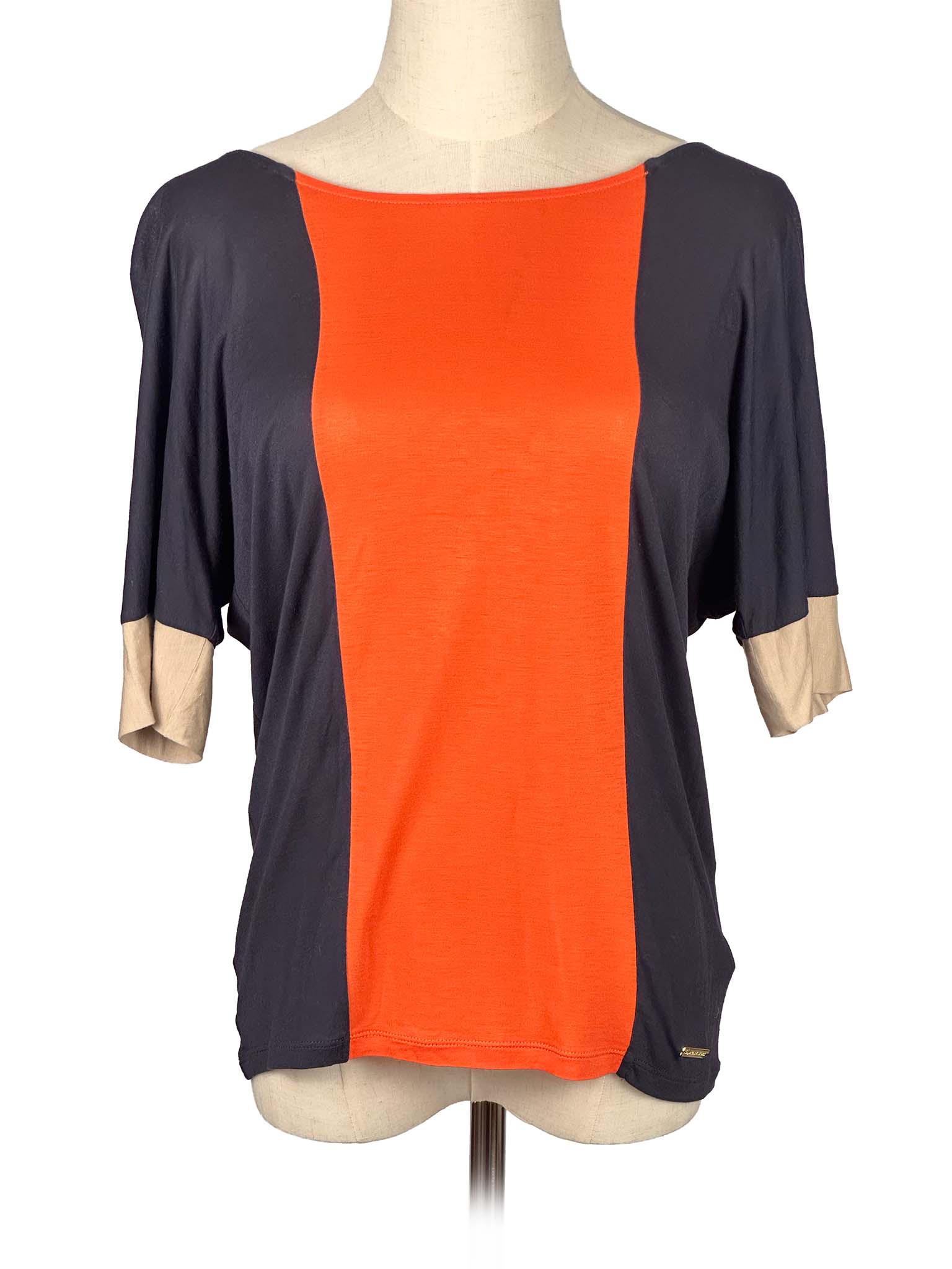 Mannequin wearing a two-tone Michael Kors shirt with orange and black sections on a white background