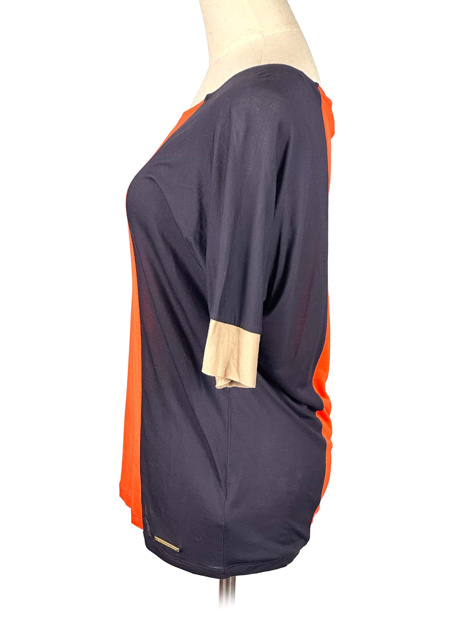 Mannequin wearing a two-tone Michael Kors shirt with orange and black sections on a white background