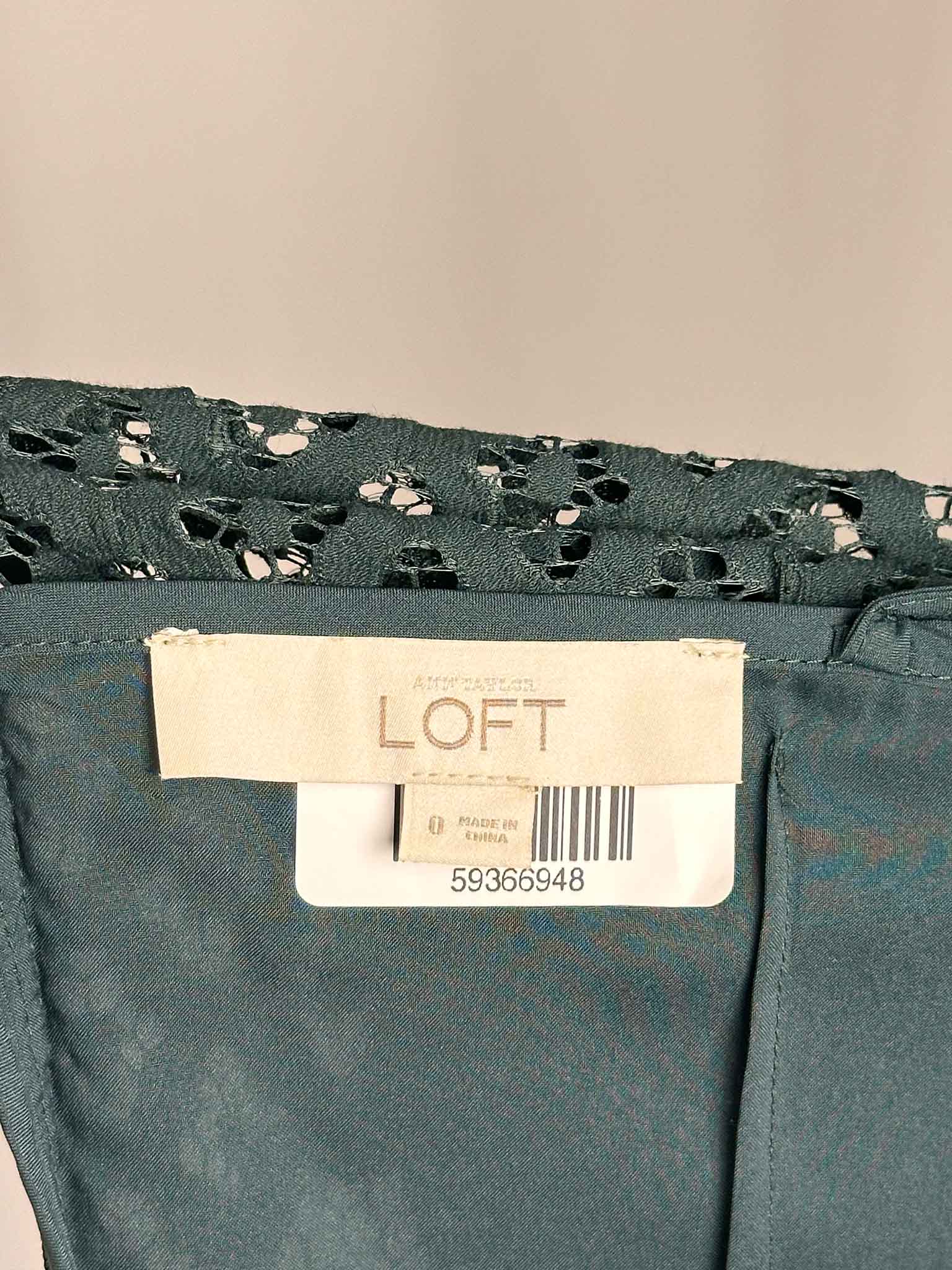 Green dress with a LOFT label on a beige background