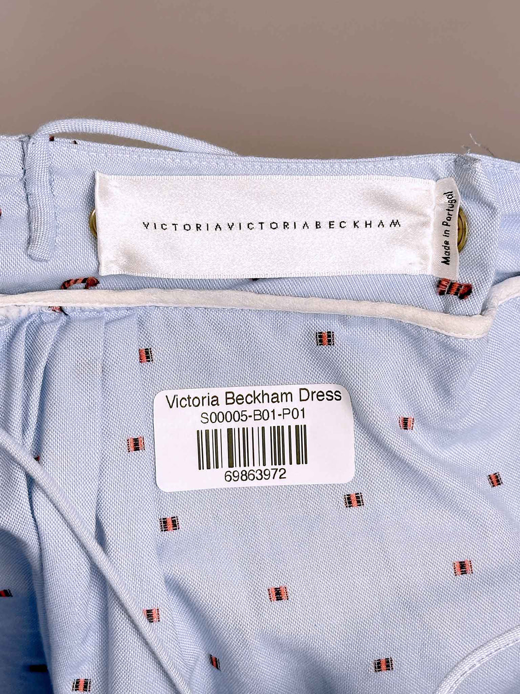 Victoria Beckham dress label on a light blue fabric background