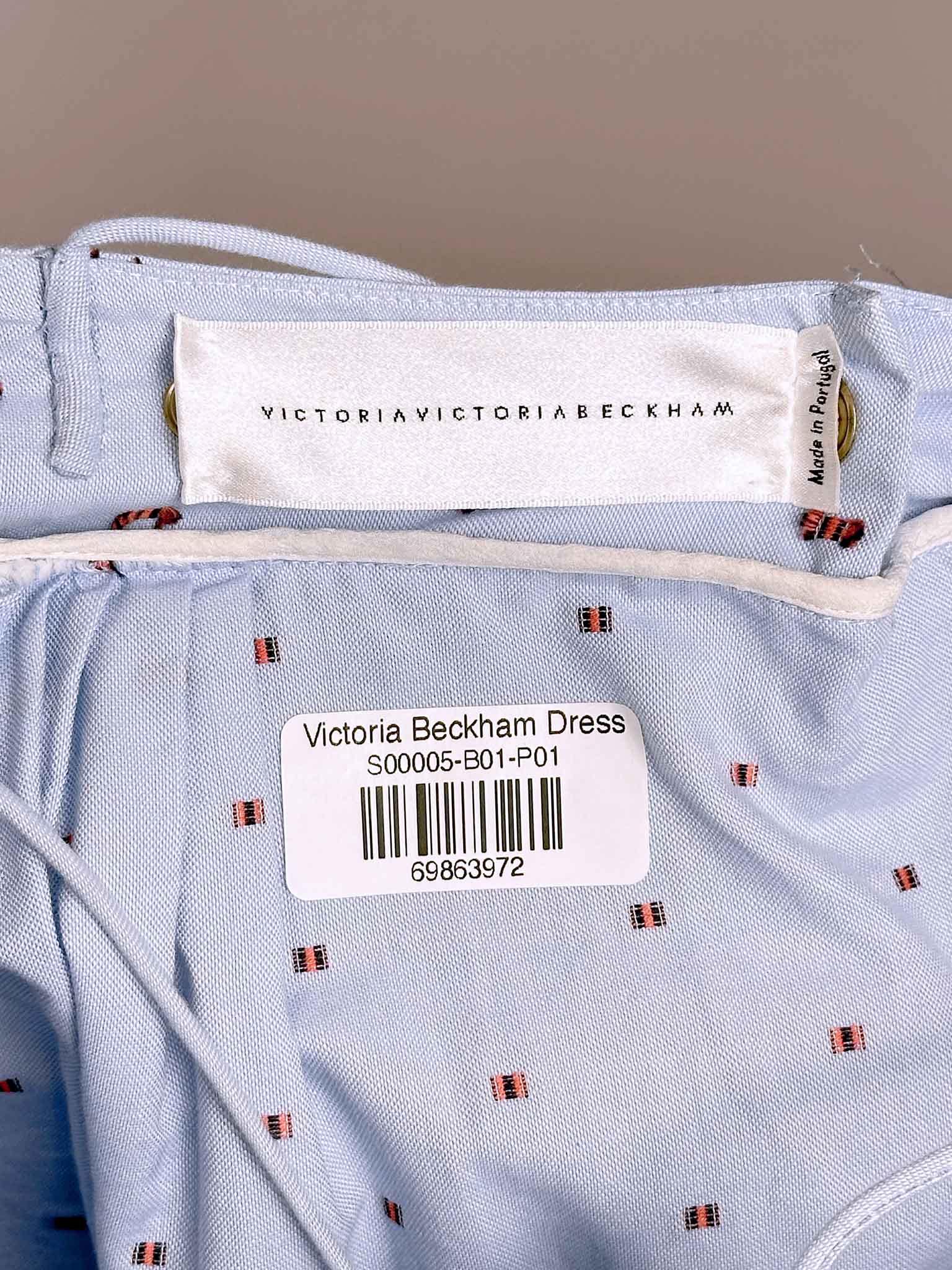 Victoria Beckham dress label on a light blue fabric background