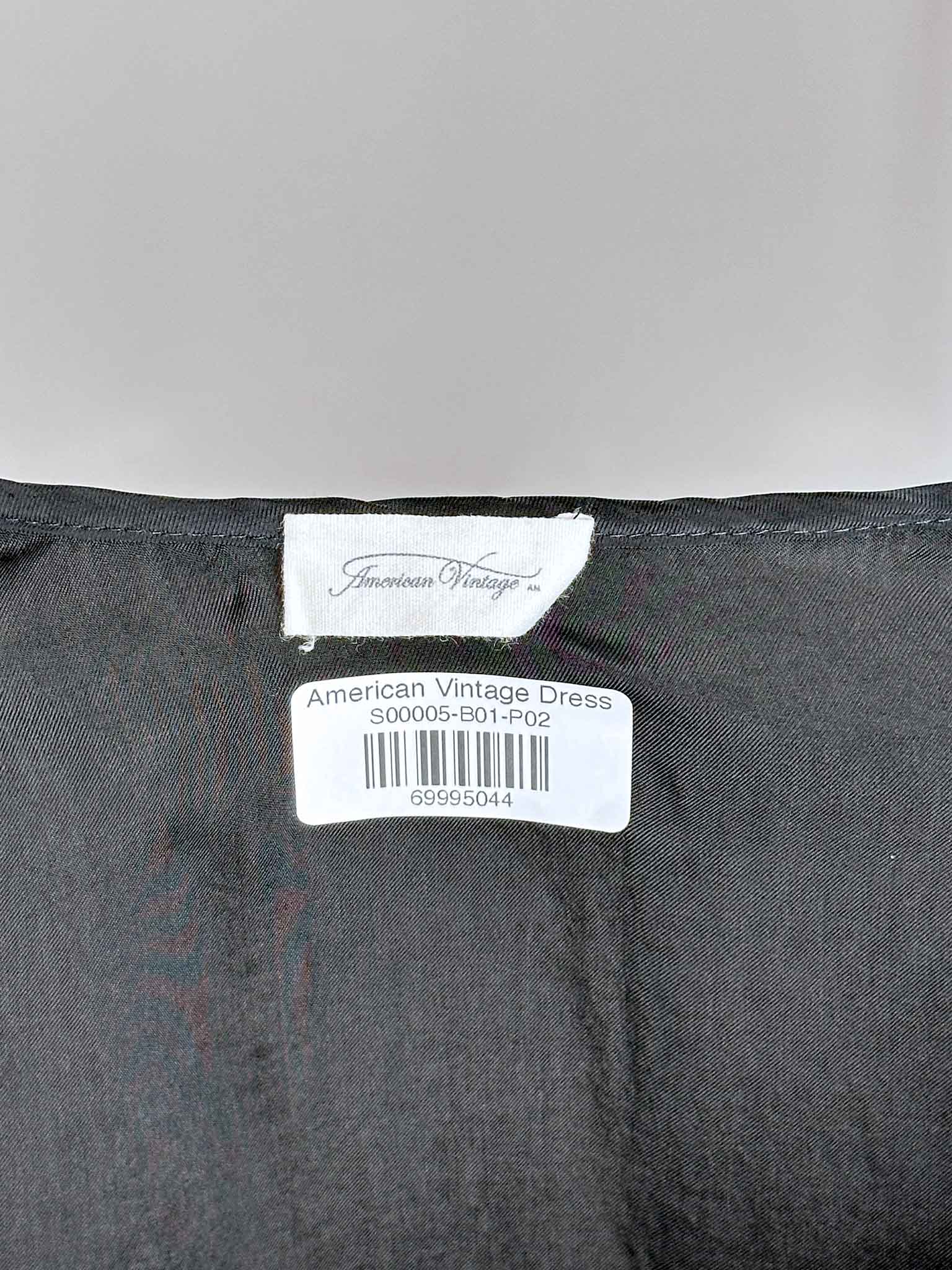 Black dress with 'American Vintage' label on a gray background