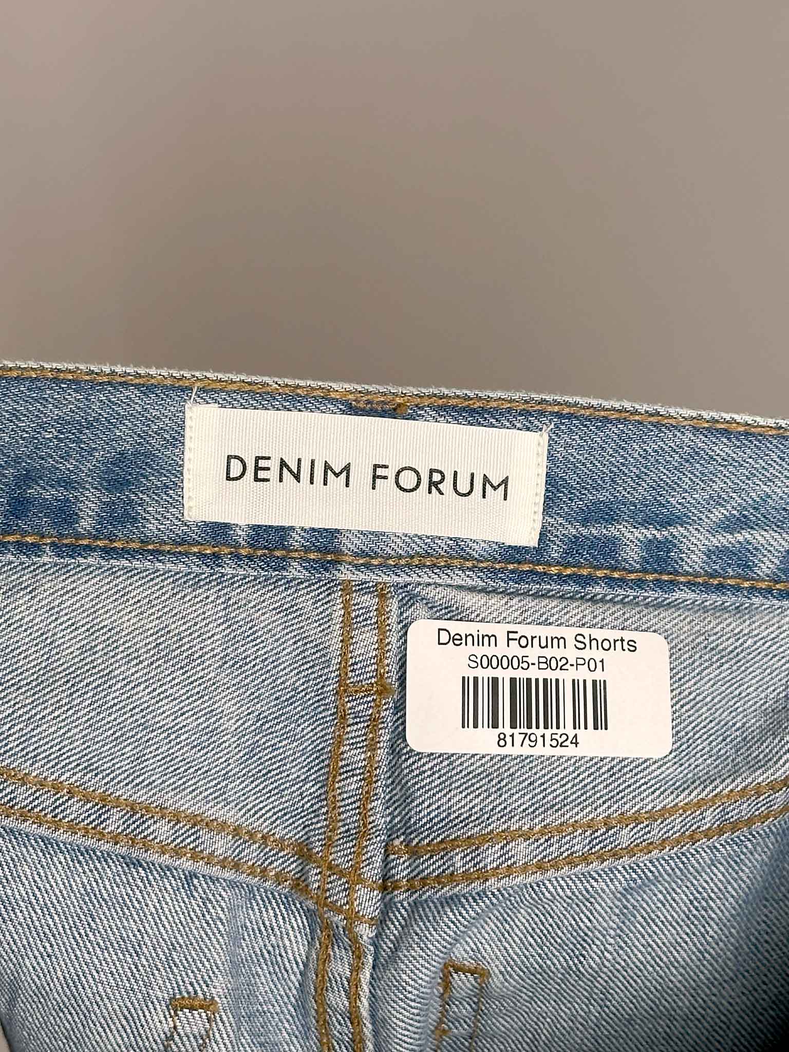 Denim shorts with 'Denim Forum' label on a blurred background