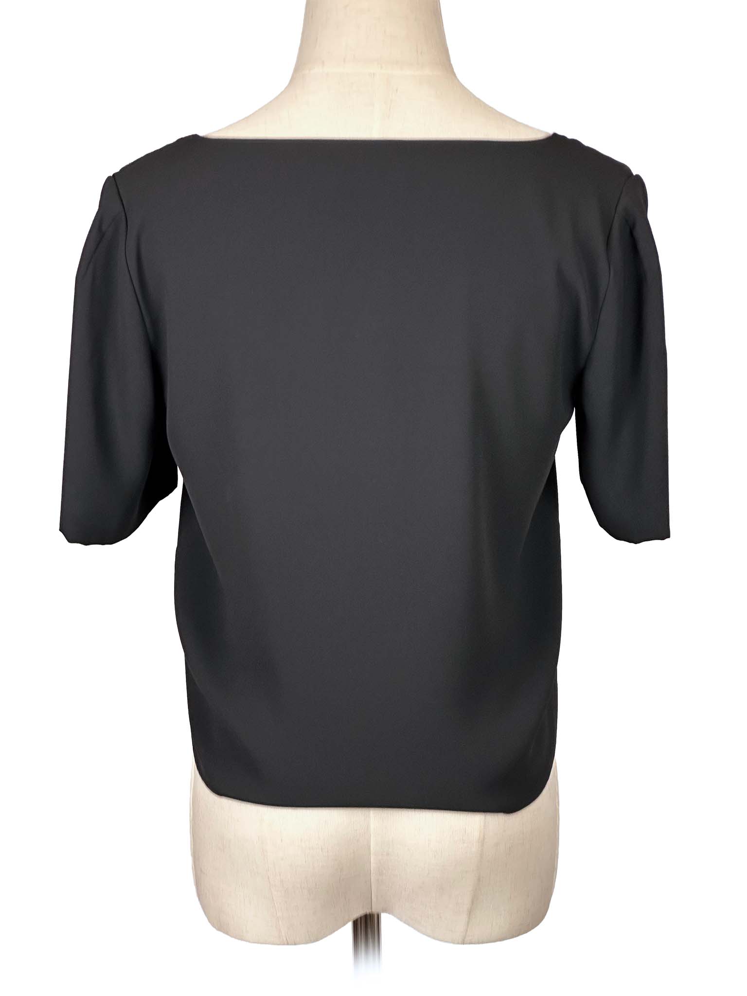 Babaton black V-neck blouse on a mannequin against a white background