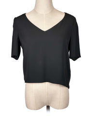 Babaton black V-neck blouse on a mannequin against a white background