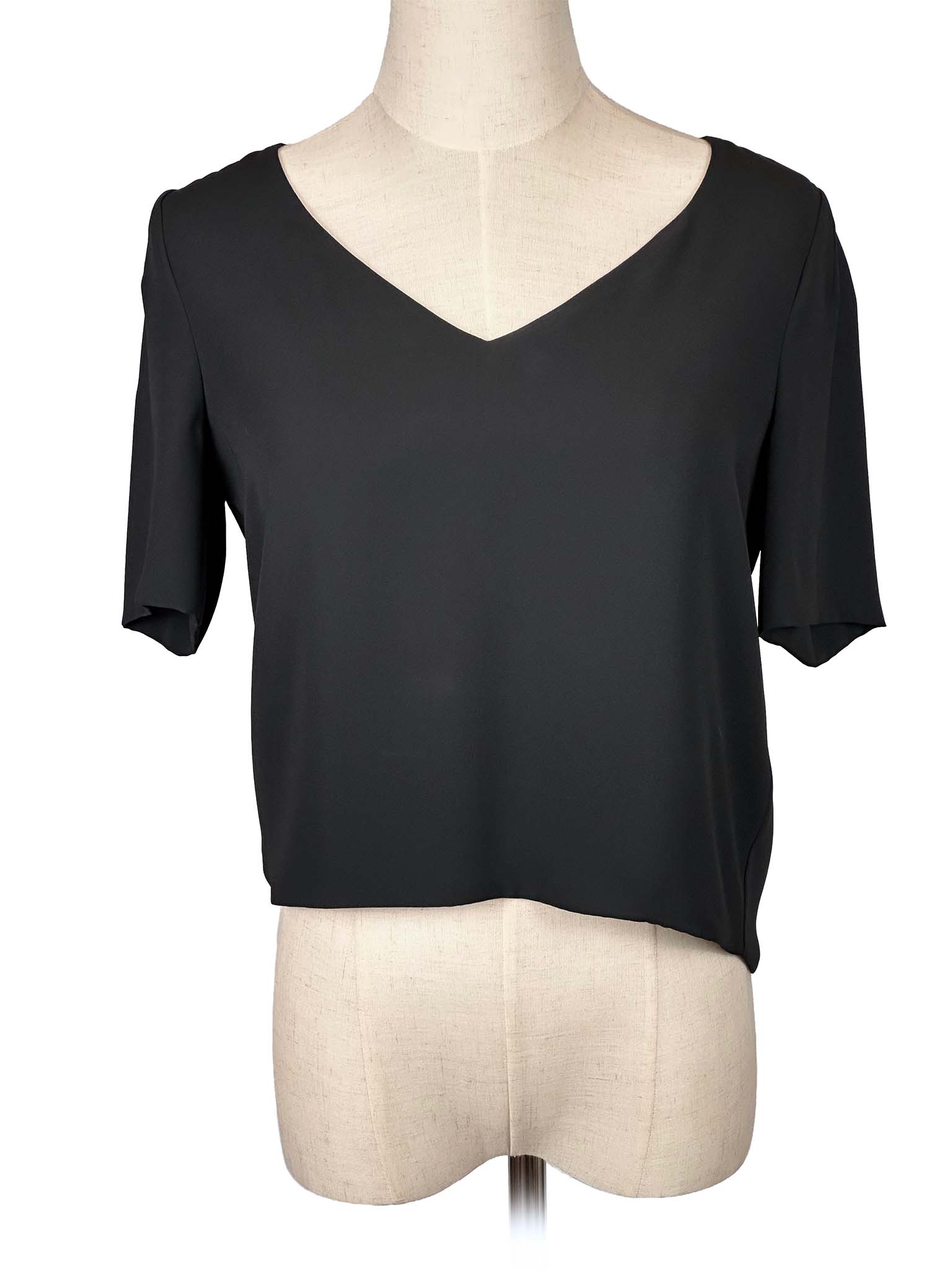 Babaton black V-neck blouse on a mannequin against a white background