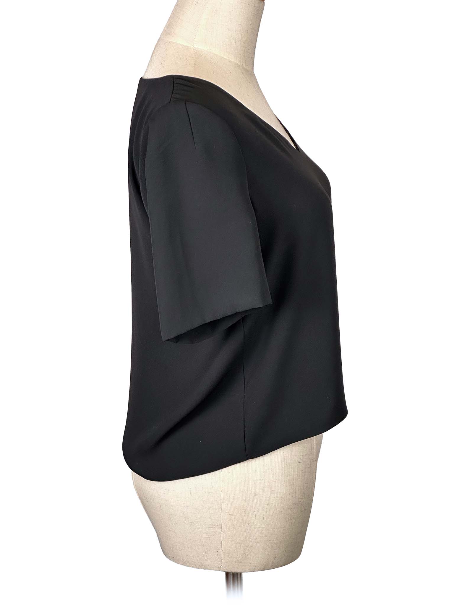 Babaton black V-neck blouse on a mannequin against a white background
