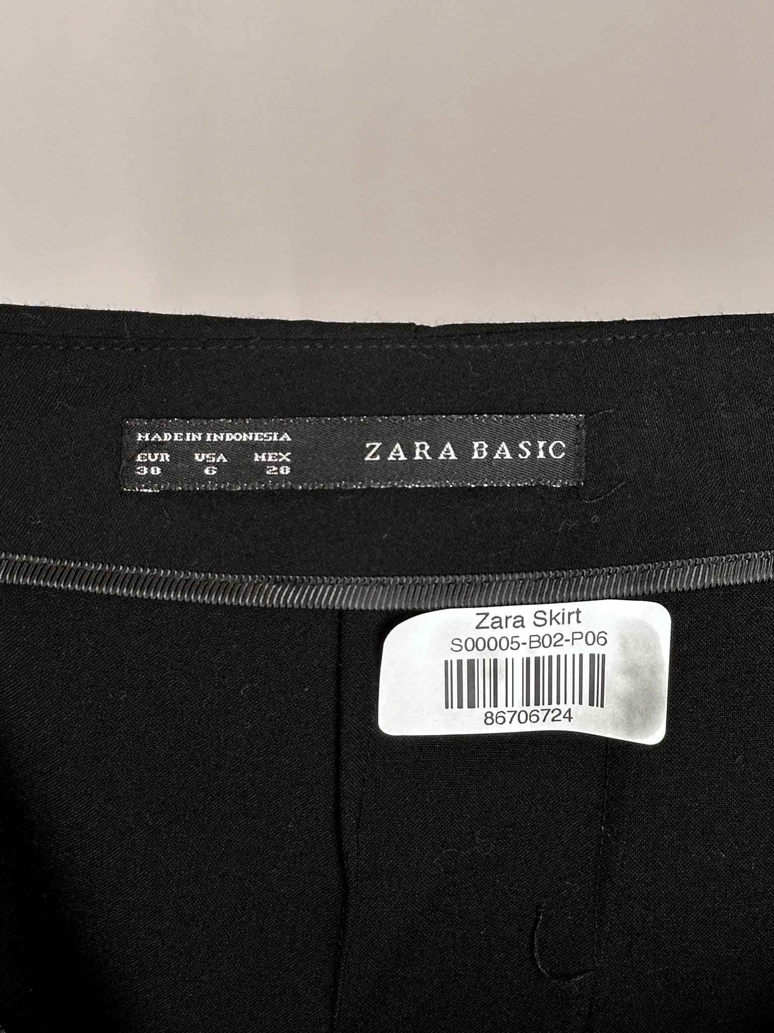 Zara Basic label on a black skirt with a beige background