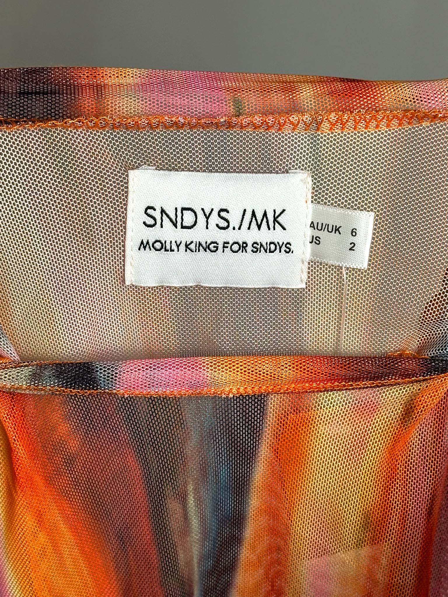 Close-up of a colorful fabric with a label reading 'SNDYS./MK Molly King for SNDYS.'