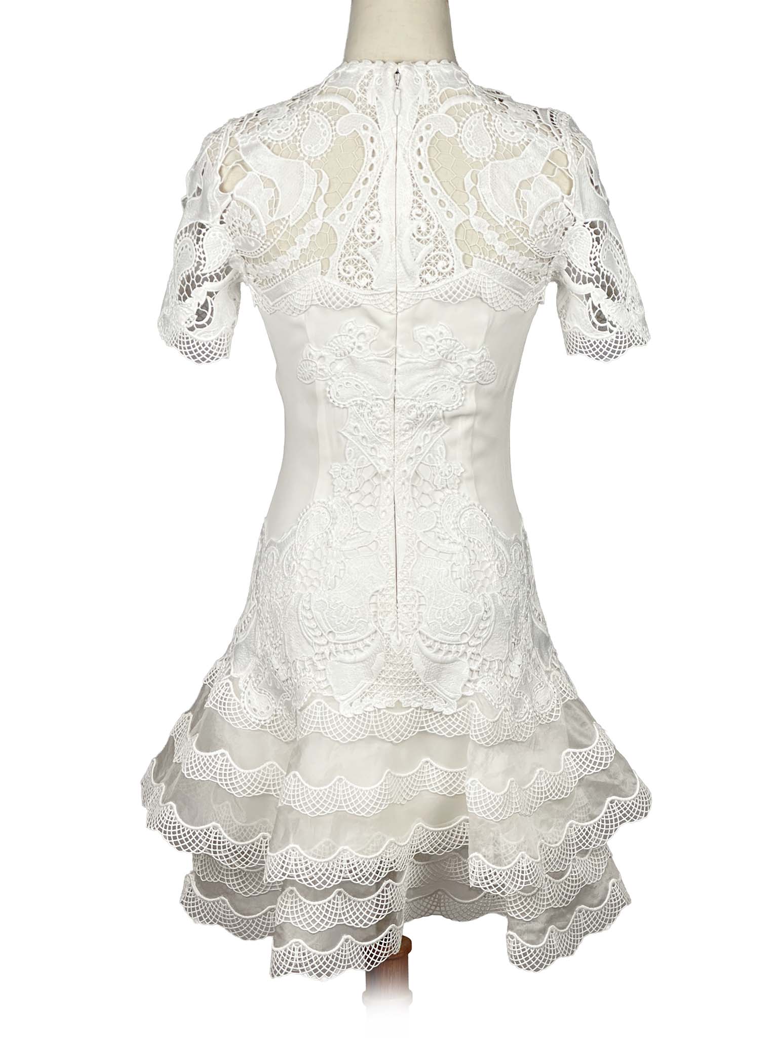 White lace Jonathan Simkhai dress on a mannequin against a white background