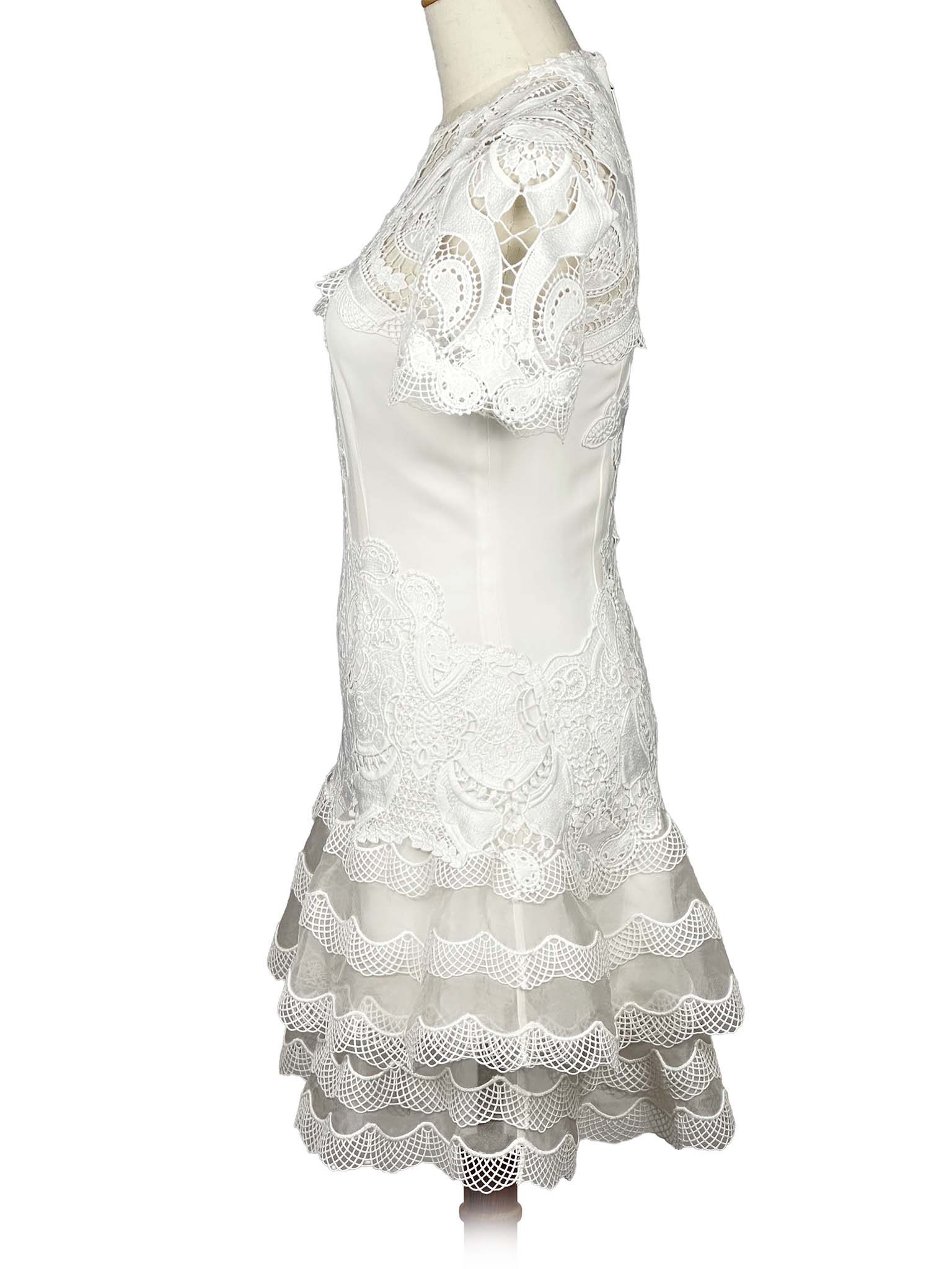 Side view of a white lace Jonathan Simkhai dress on a mannequin against a white background
