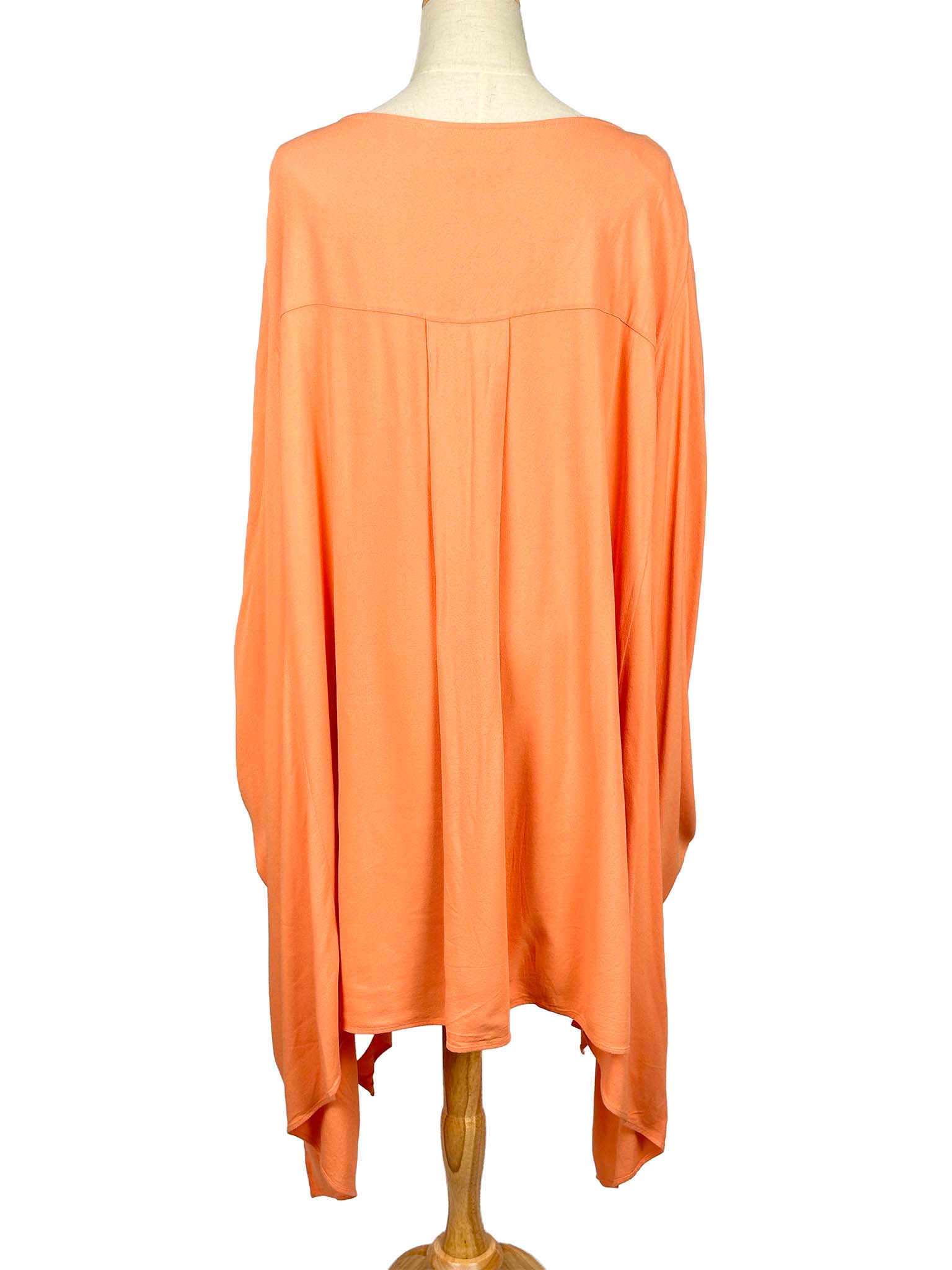 COS orange poncho-style dress on a mannequin against a white background