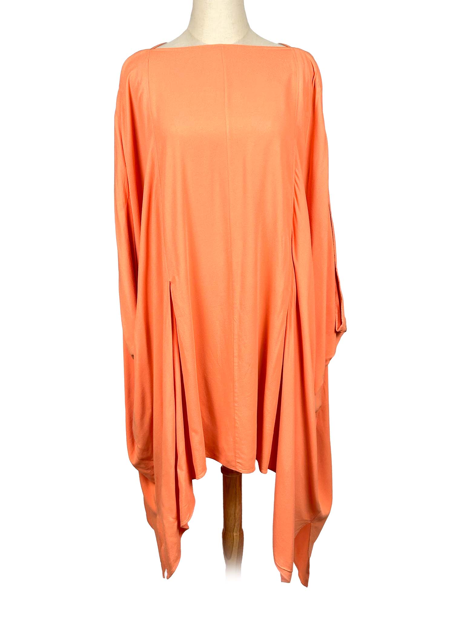 COS orange poncho-style dress on a mannequin against a white background