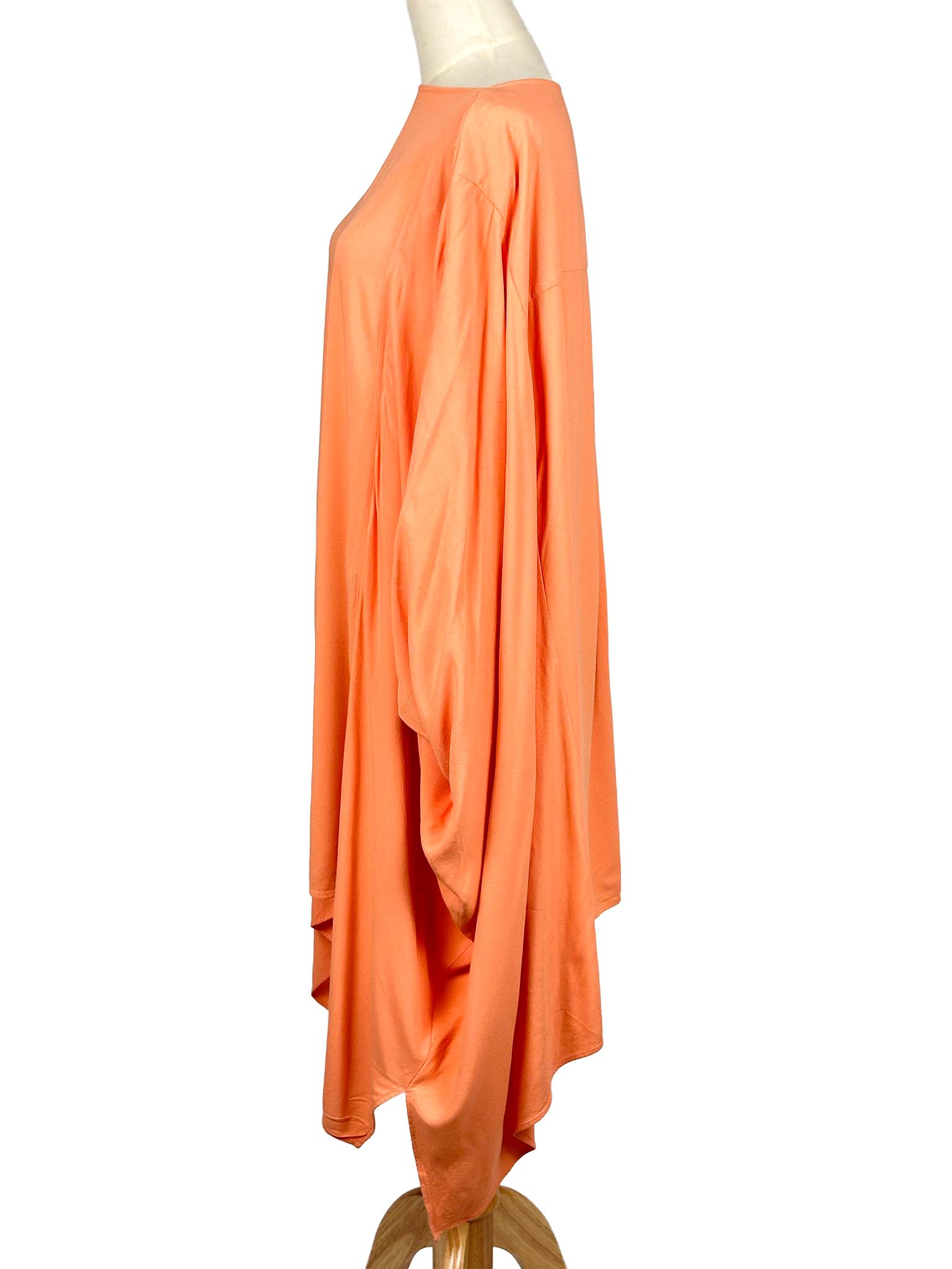 COS orange poncho-style dress on a mannequin against a white background