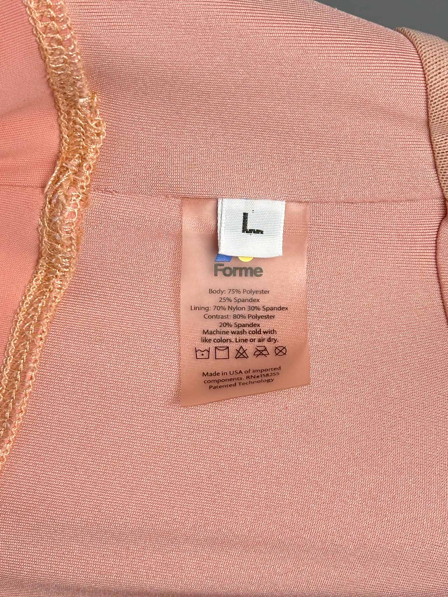 Pink fabric with a 'Forme' label showing material information.