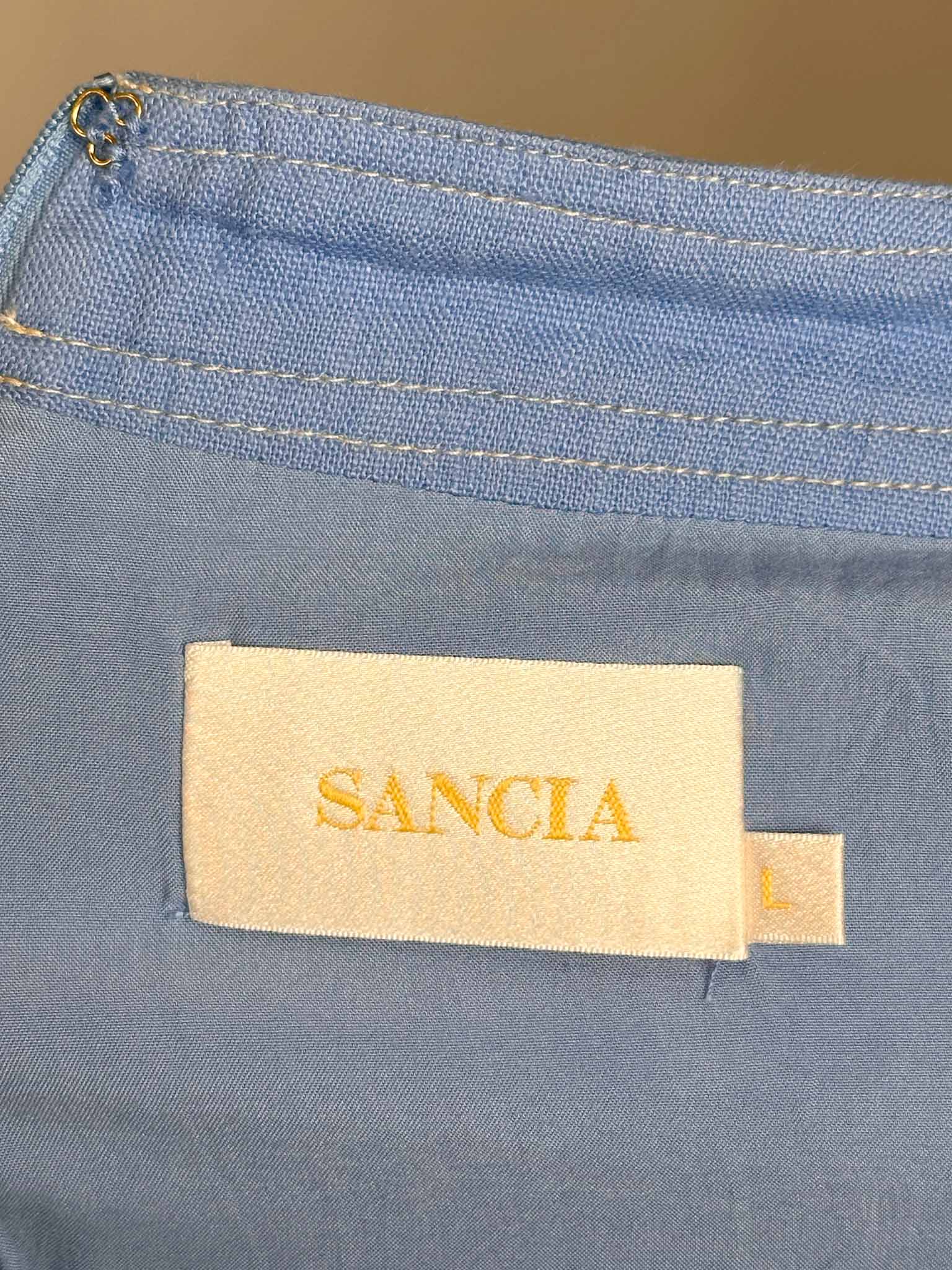 Close-up of a blue fabric with a 'Sancia' label.