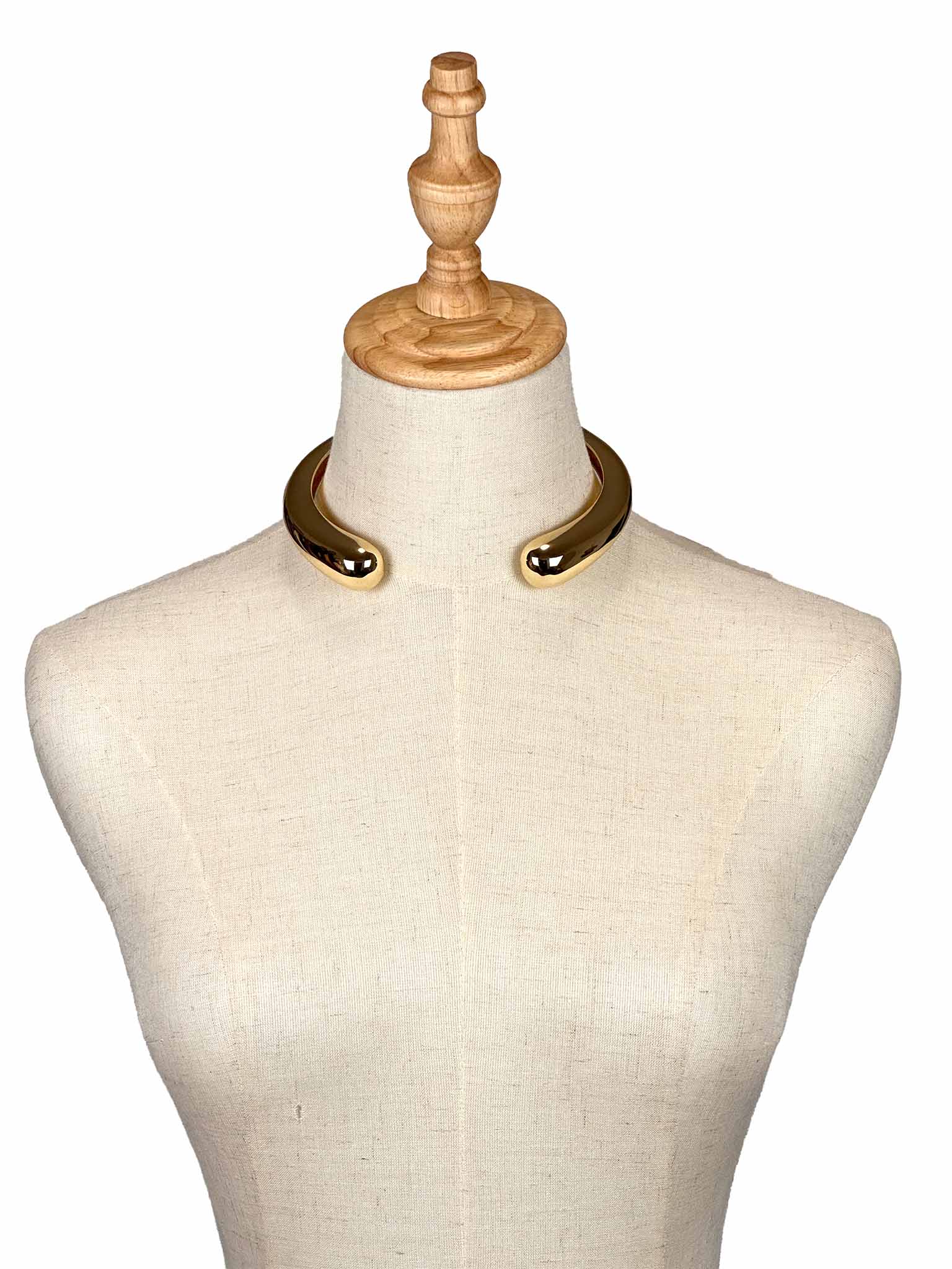 Mannequin wearing a Zara golden necklace on a white background