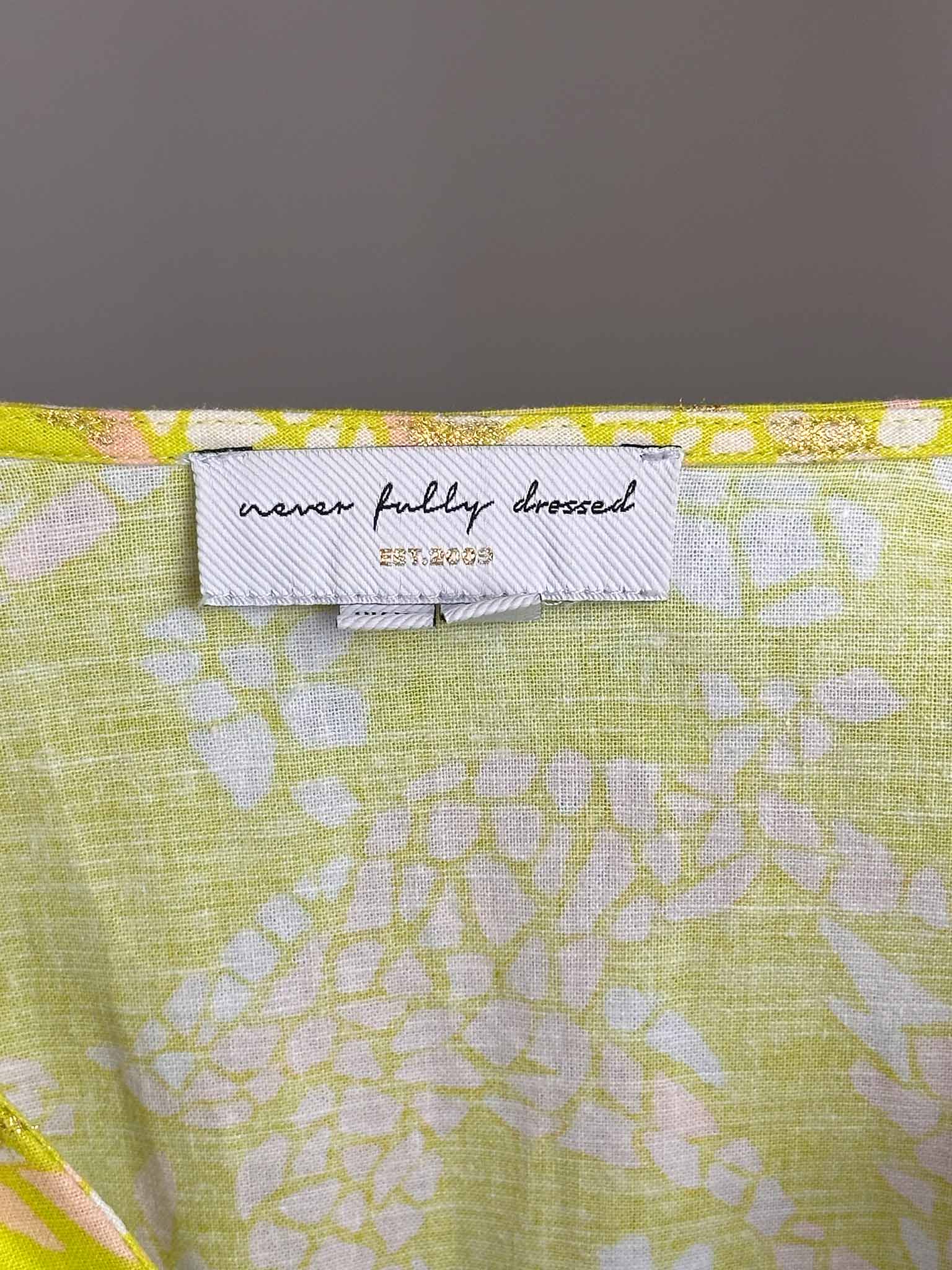 Floral fabric with a label reading 'never fully dressed' on a dark background