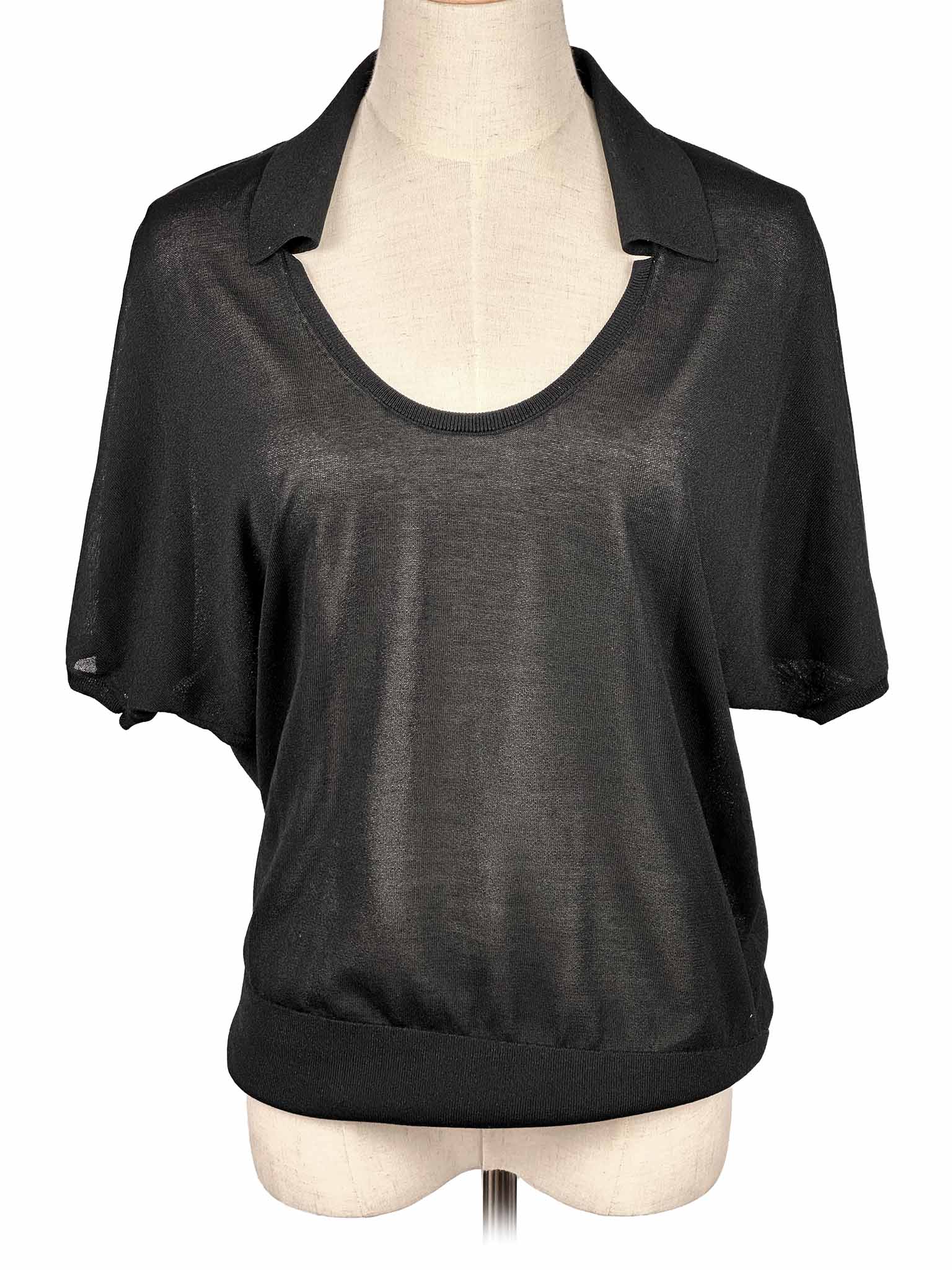 COS black blouse on a mannequin with a white background