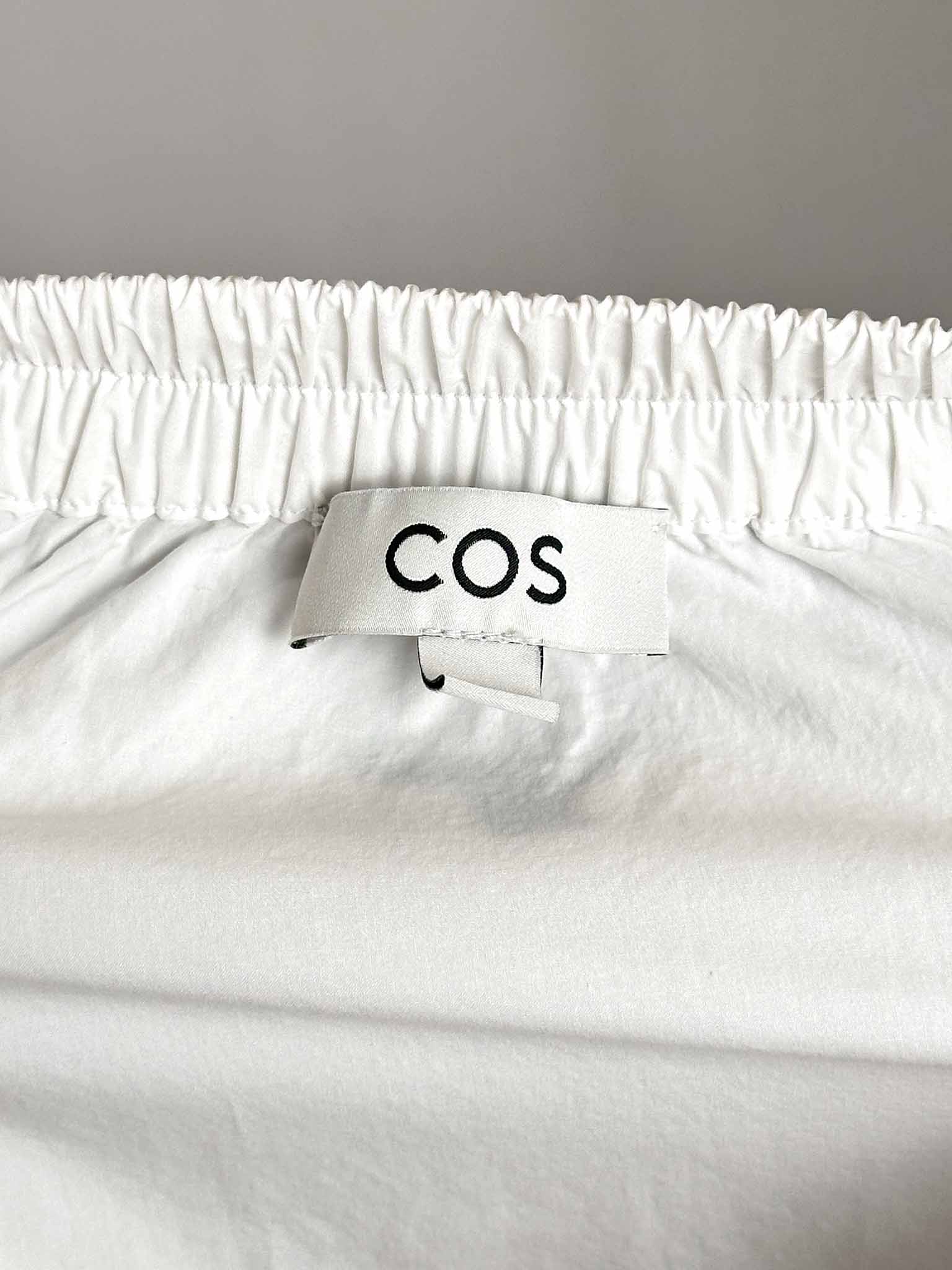 White fabric with a COS label on a gray background